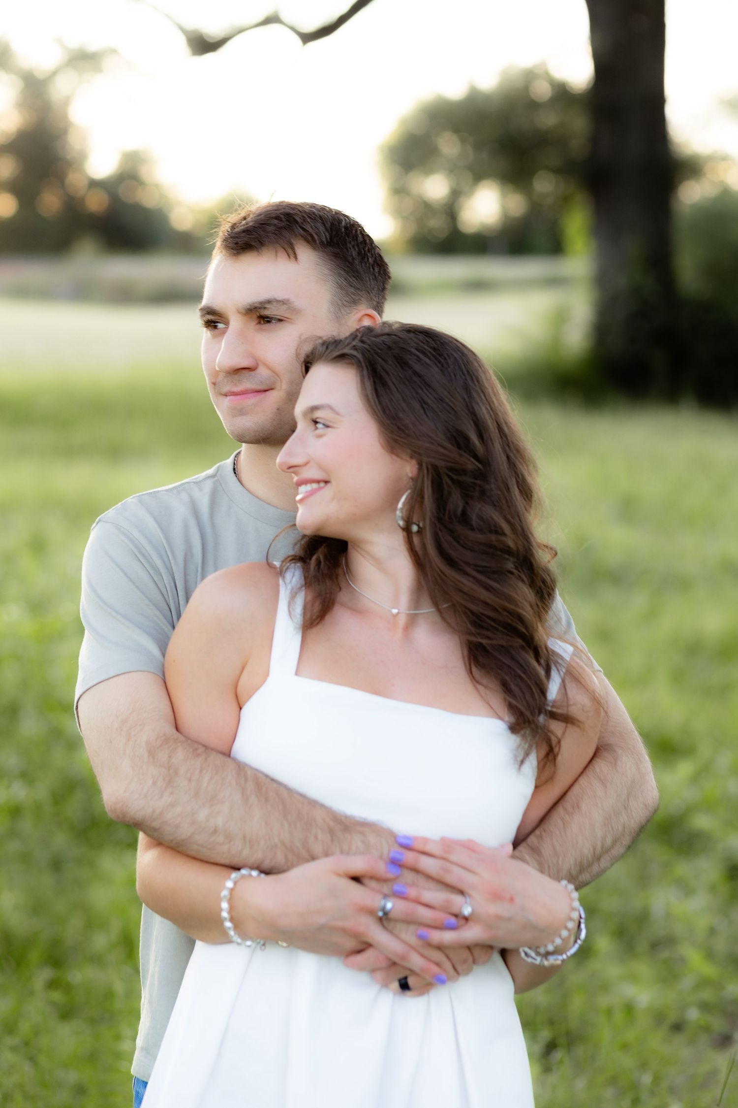 Couple holding each other in a grass field at sunset in Dothan, Alabama