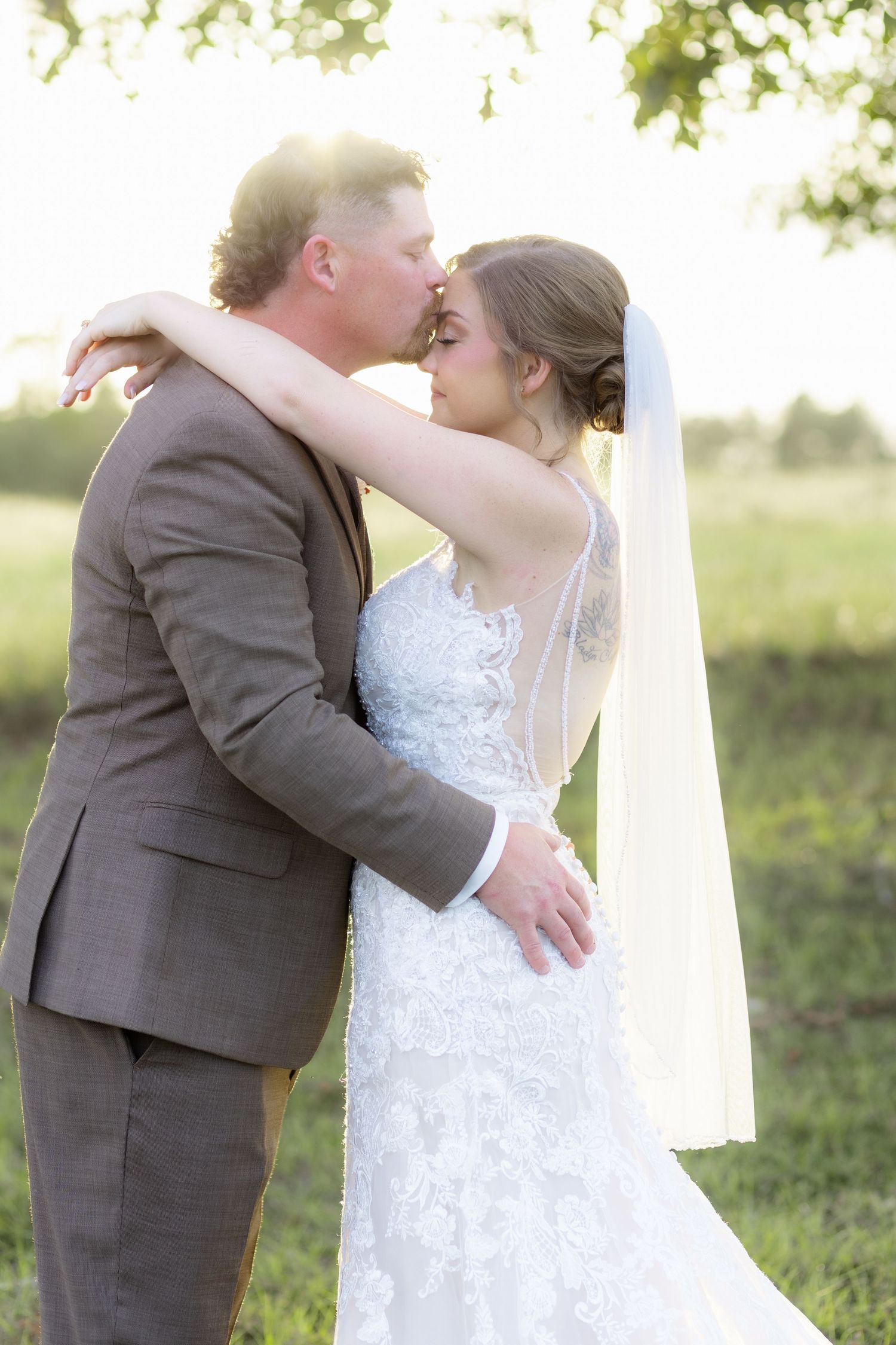 Bride and groom hold each other at sunset at Hilltop Acres Wicksburg, Alabama