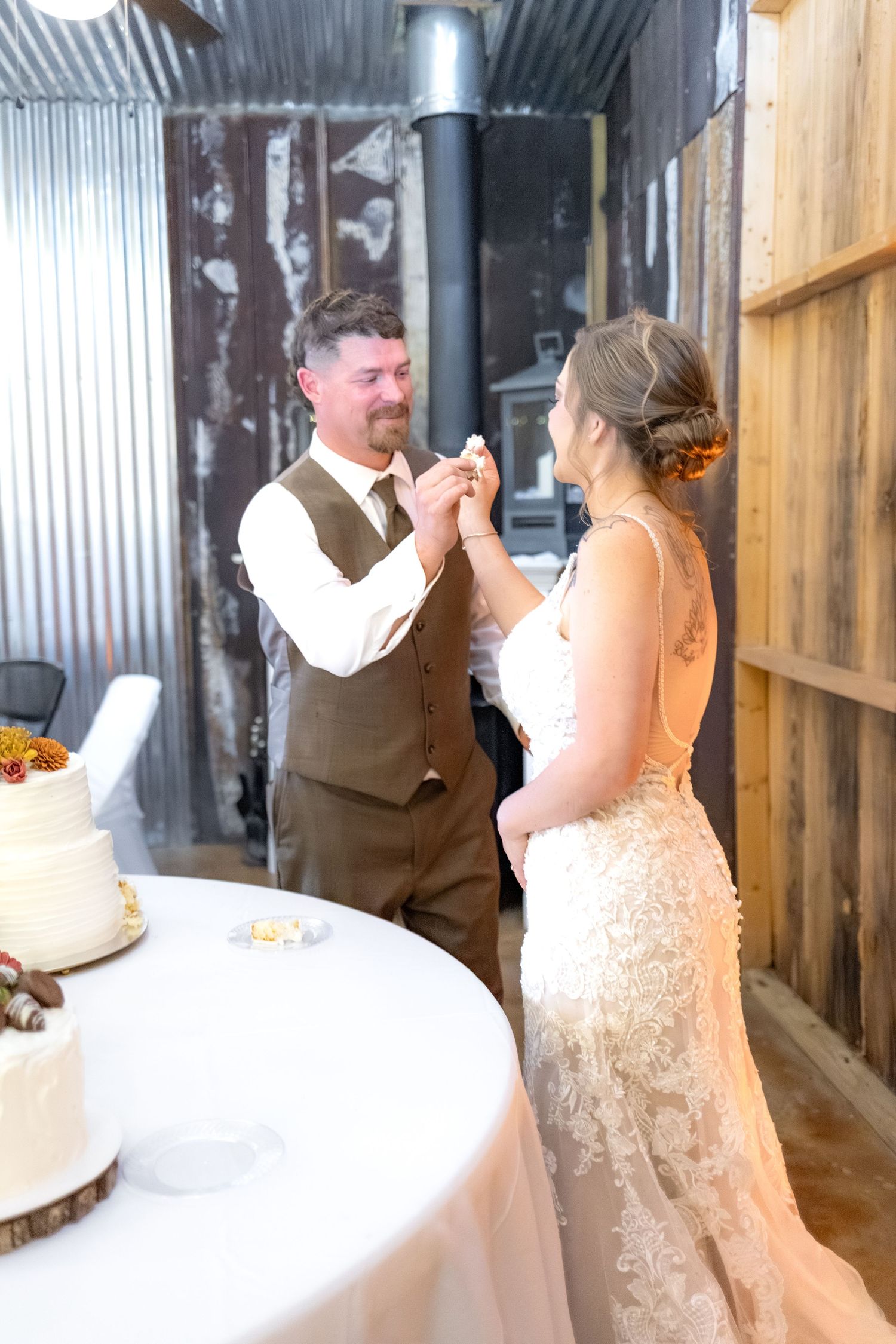 Bride and groom cut cake at their barn wedding at Hilltop Acres Wicksburg, Alabama