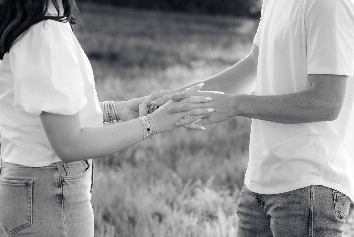 Romantic couple photos in a natural grass field setting with large trees at sunset.