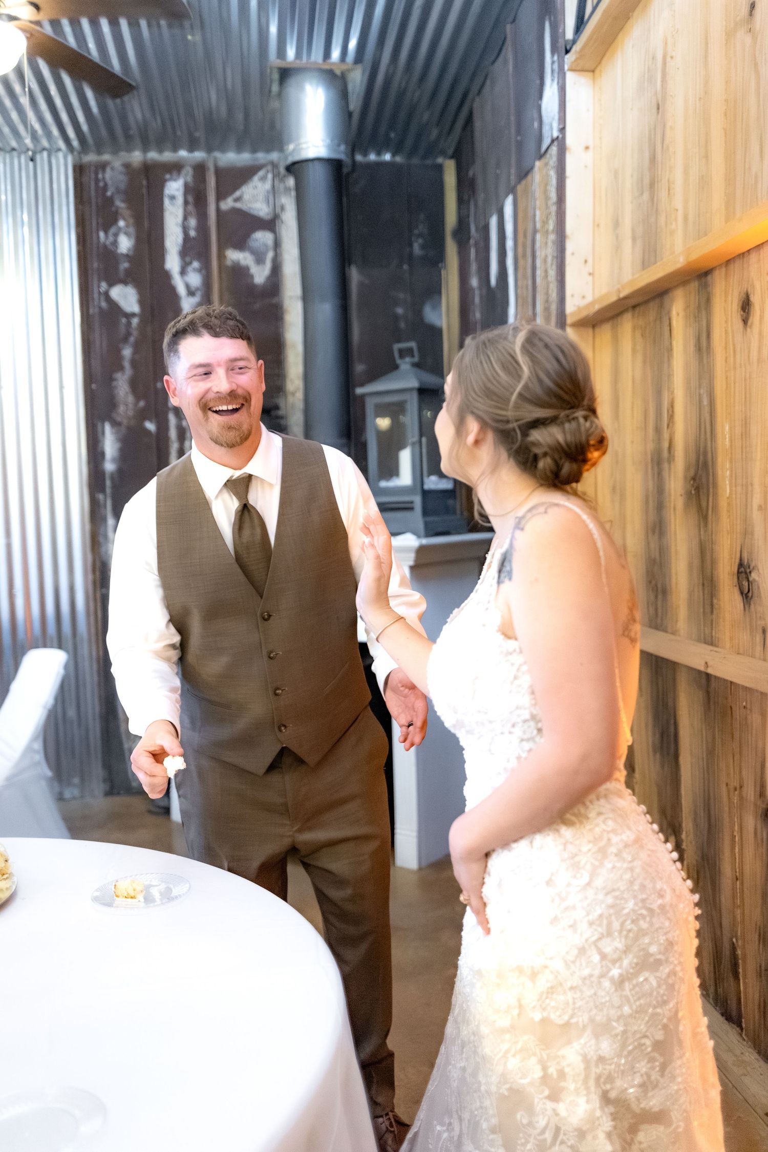 Bride and groom cut cake at their barn wedding at Hilltop Acres Wicksburg, Alabama