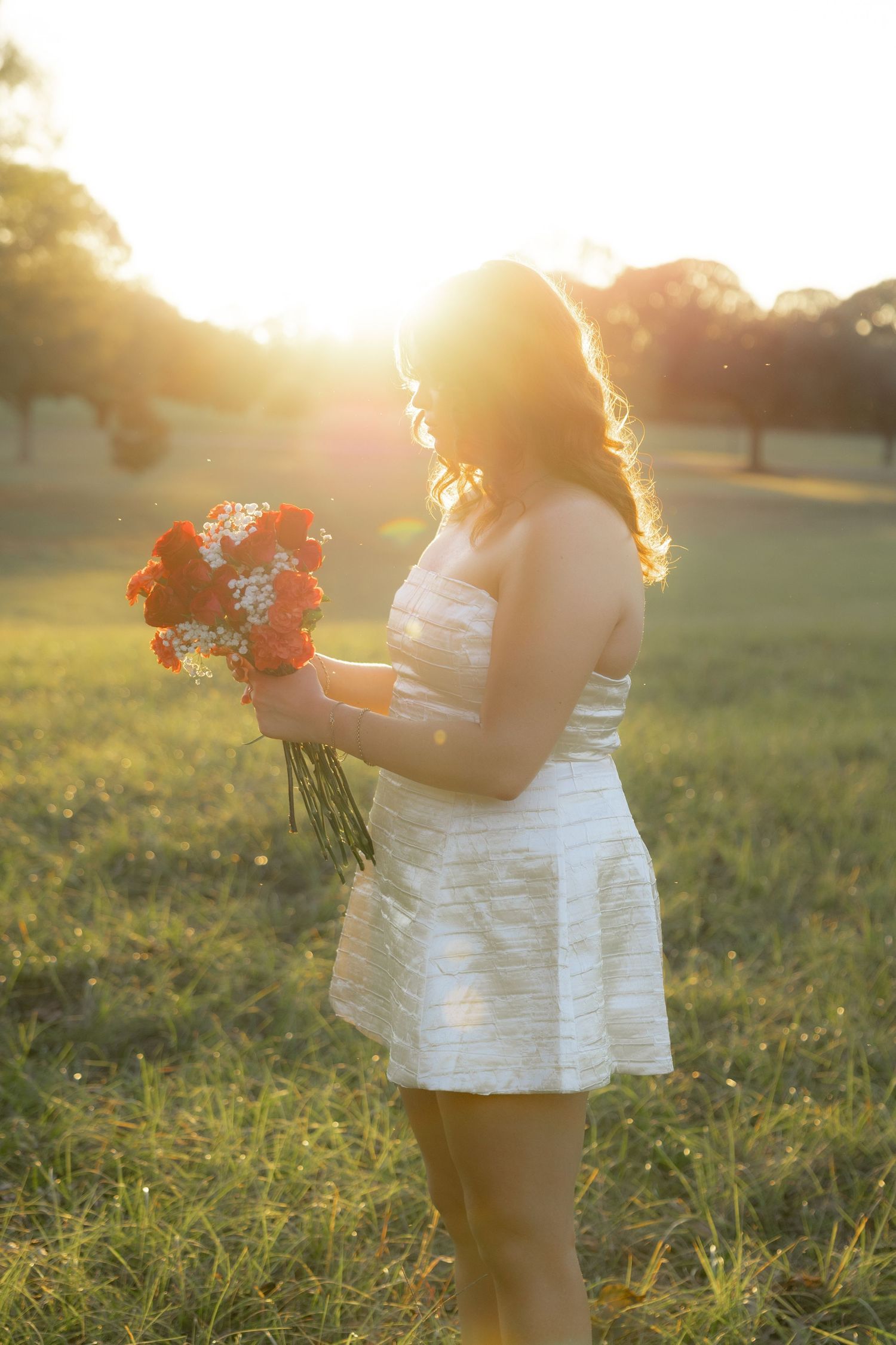 Senior pictures in a field at sunset at Troy University Dothan Campus
