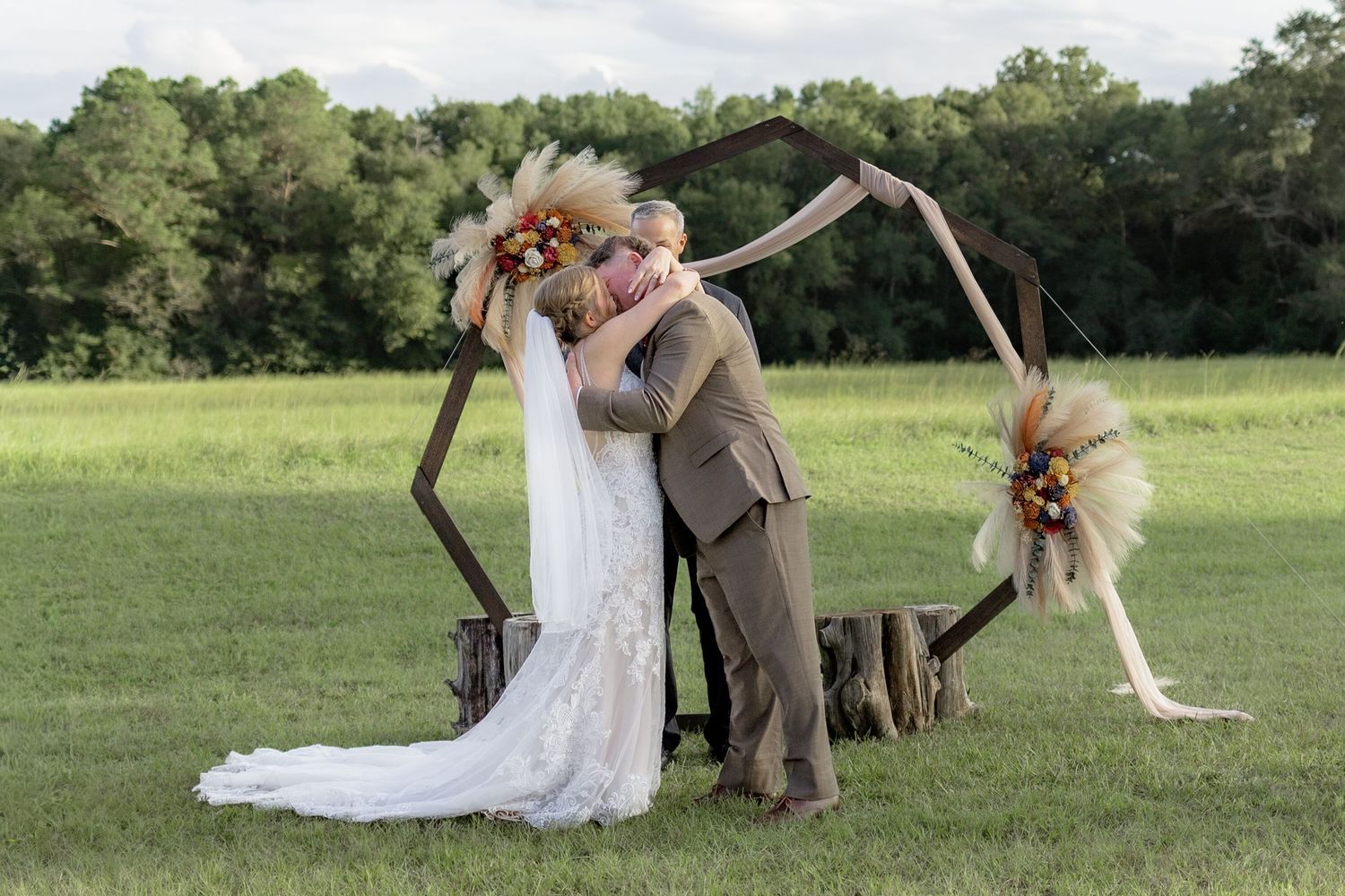 Bride and groom kiss at the altar after getting married at Hilltop Acres Wicksburg, Alabama