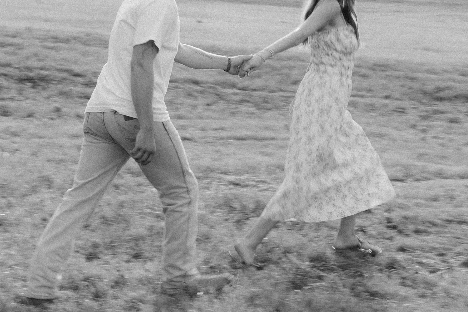 Romantic couple photos in a natural grass field setting with large trees at sunset.