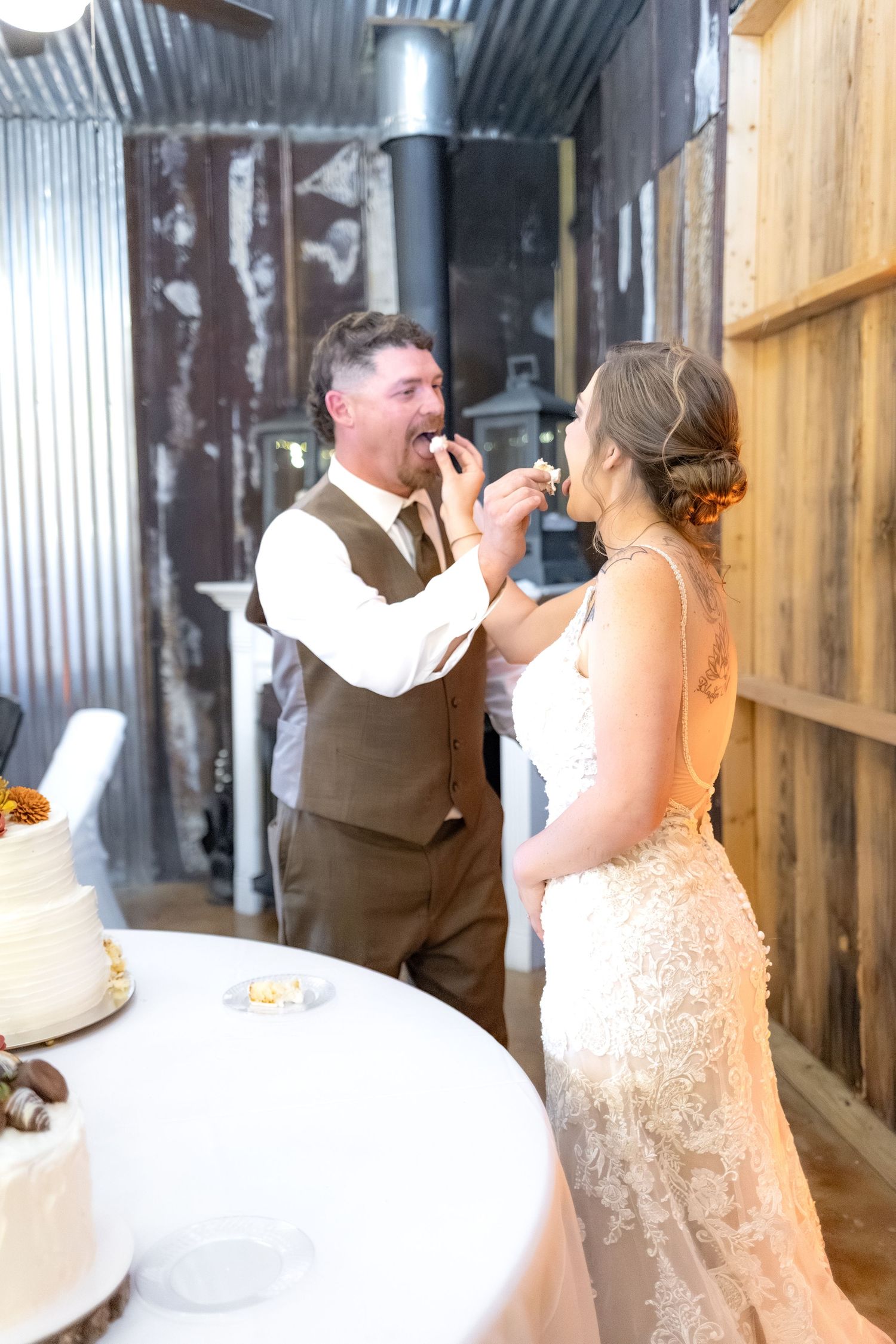 Bride and groom cut cake at their barn wedding at Hilltop Acres Wicksburg, Alabama