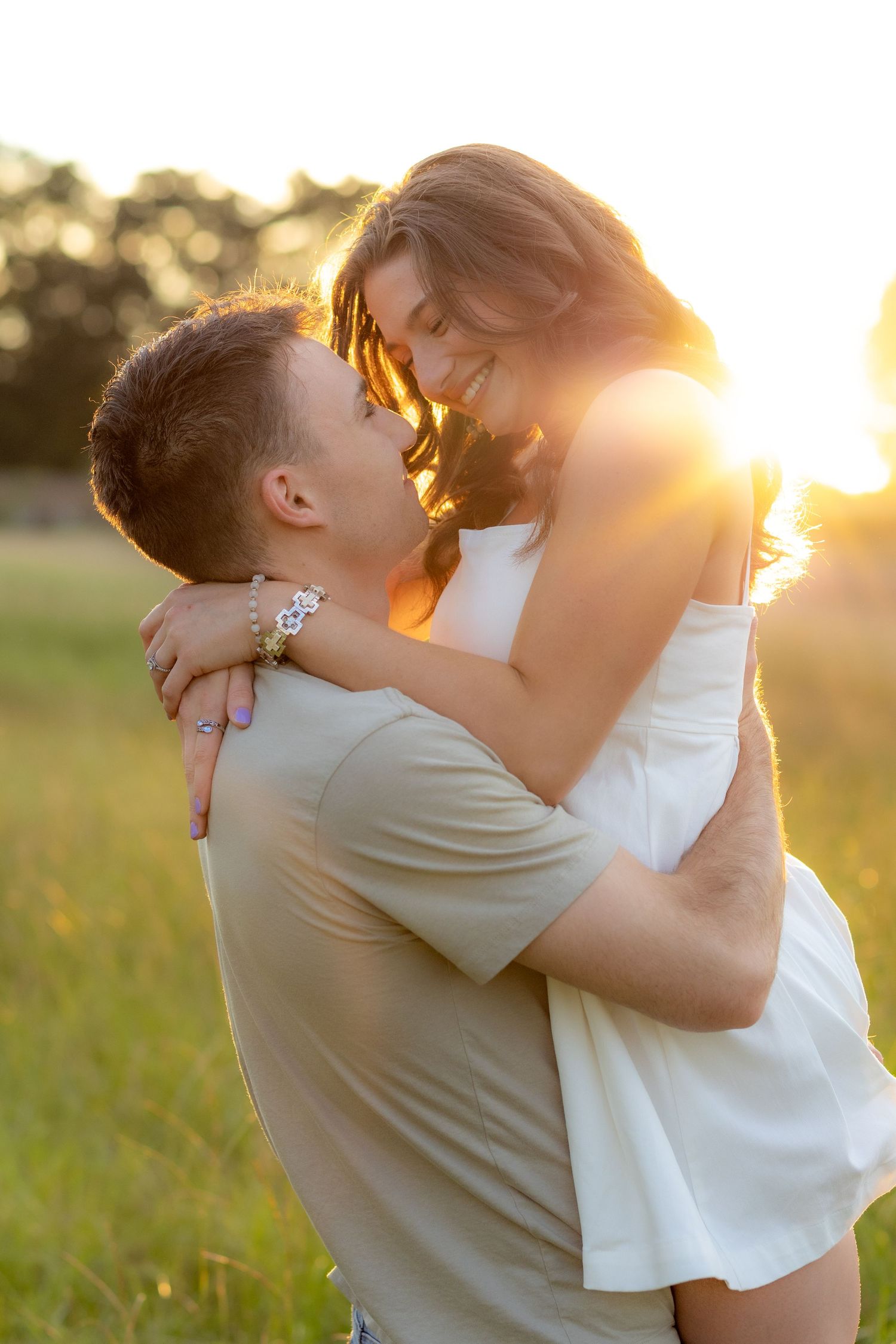 Couple holding each other in a grass field at sunset in Dothan, Alabama
