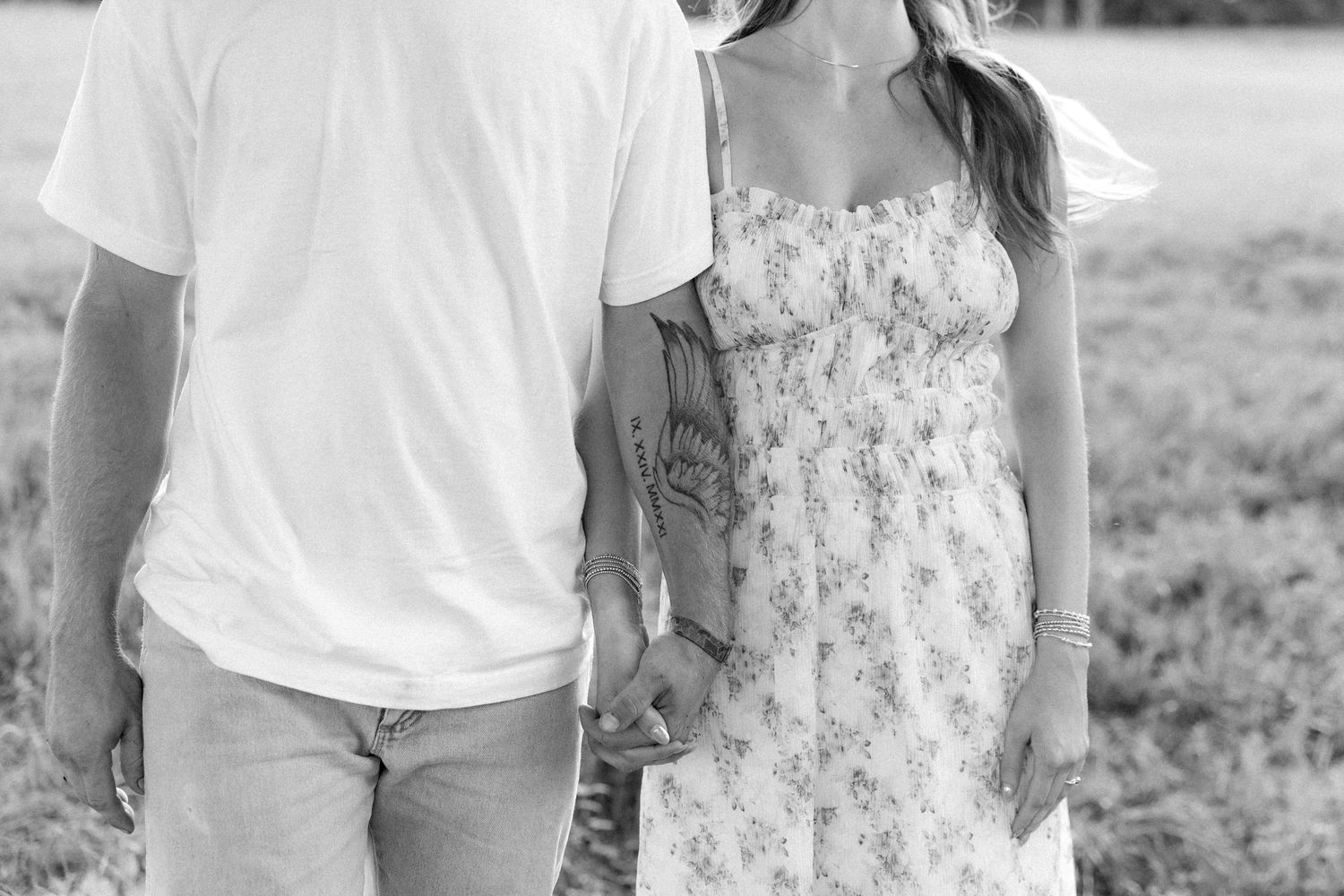 Romantic couple photos in a natural grass field setting with large trees at sunset.