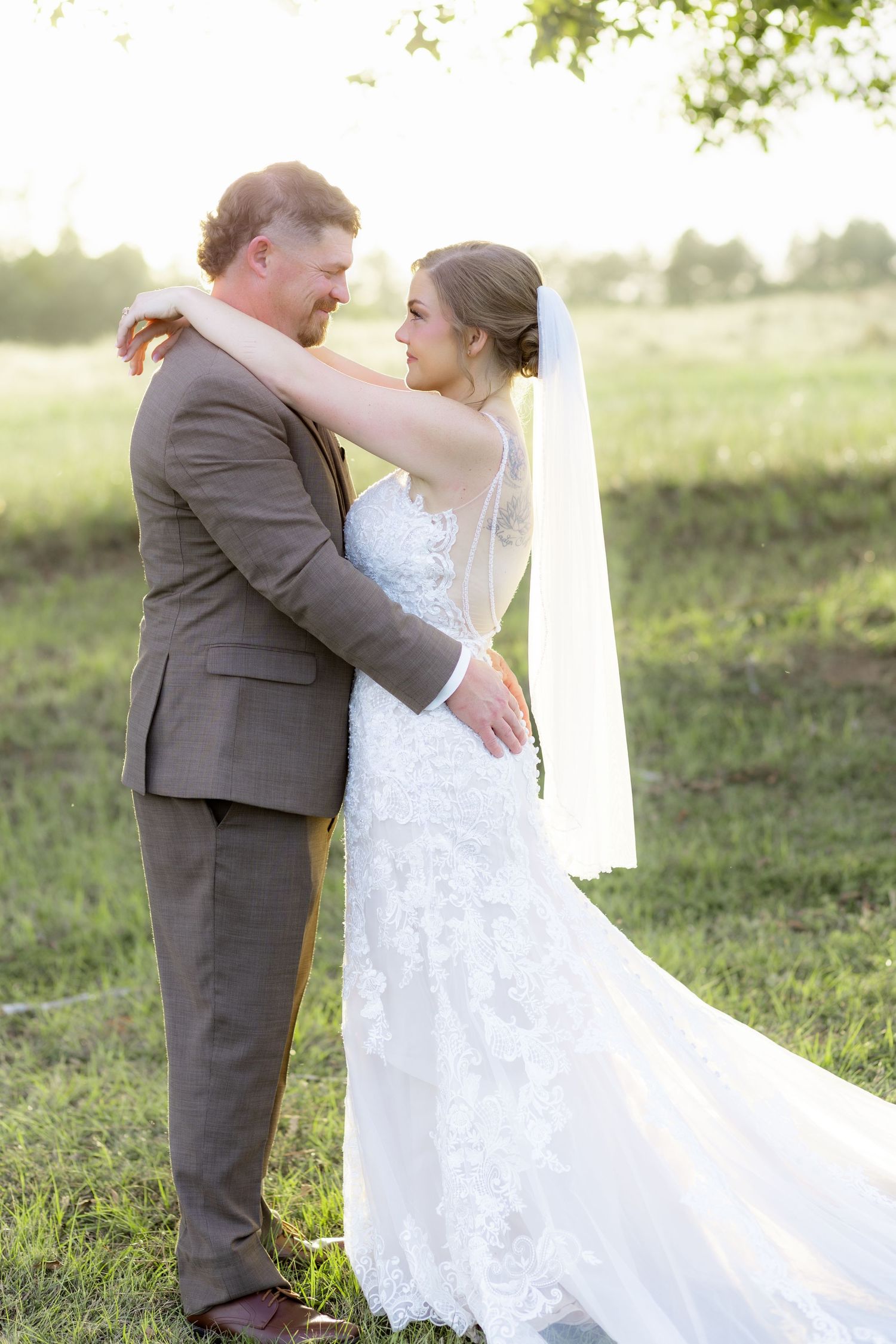Bride and groom hold each other at sunset at Hilltop Acres Wicksburg, Alabama