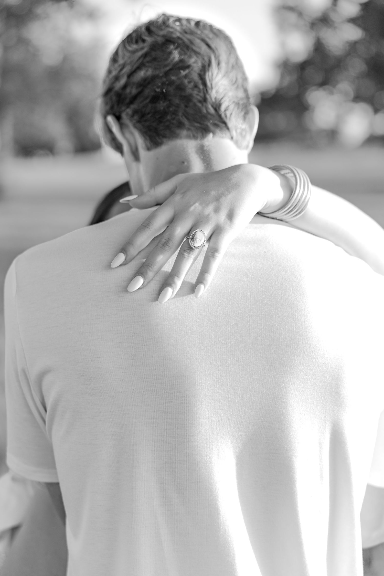 Romantic couple photos in a natural grass field setting with large trees at sunset.
