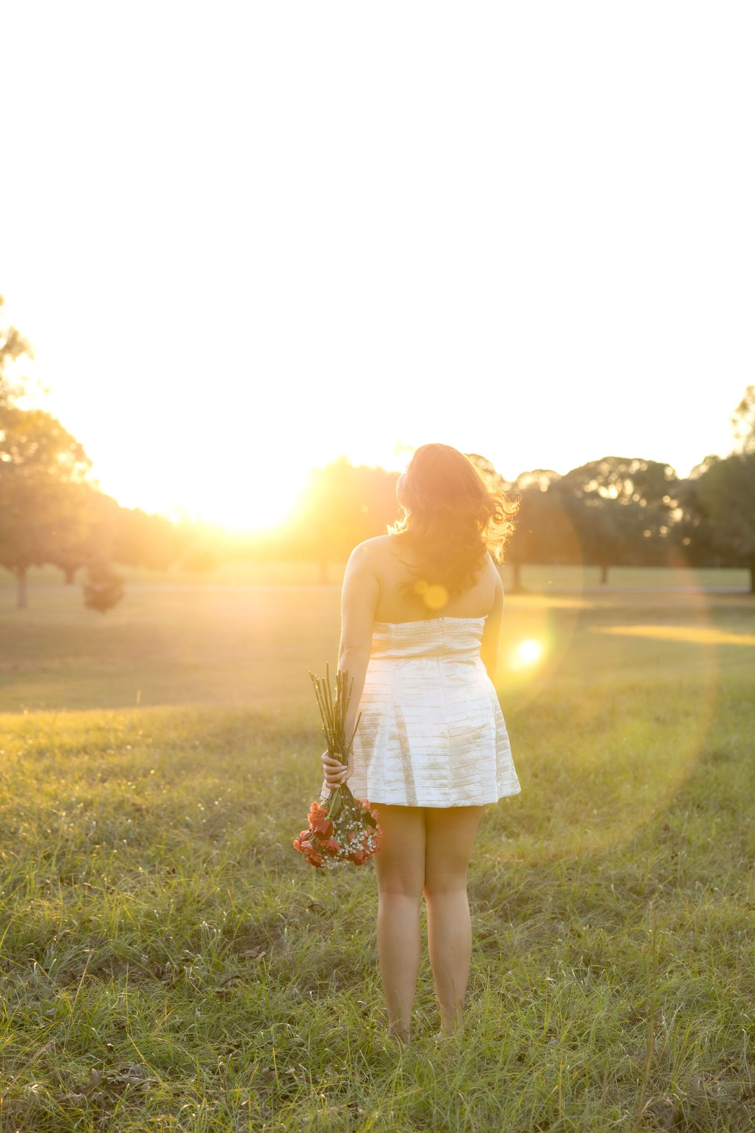 Senior pictures in a field at sunset at Troy University Dothan Campus