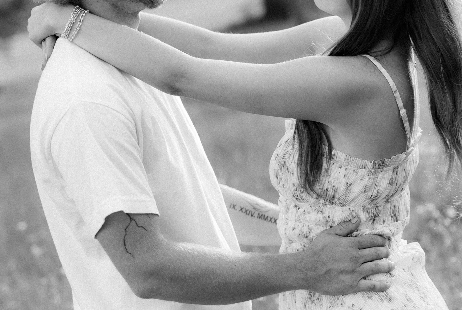 Romantic couple photos in a natural grass field setting with large trees at sunset.