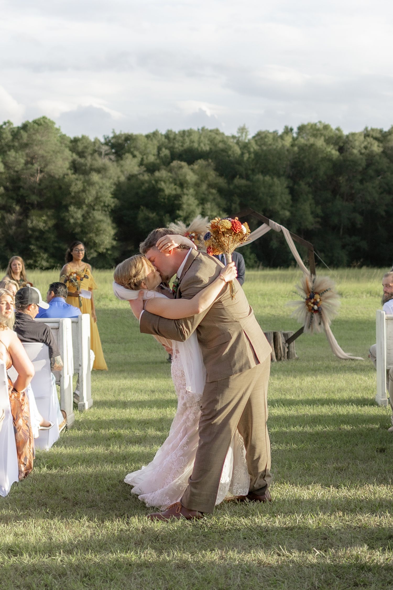 Bride and groom dip kiss exiting their ceremony at Hilltop Acres Wicksburg, Alabama
