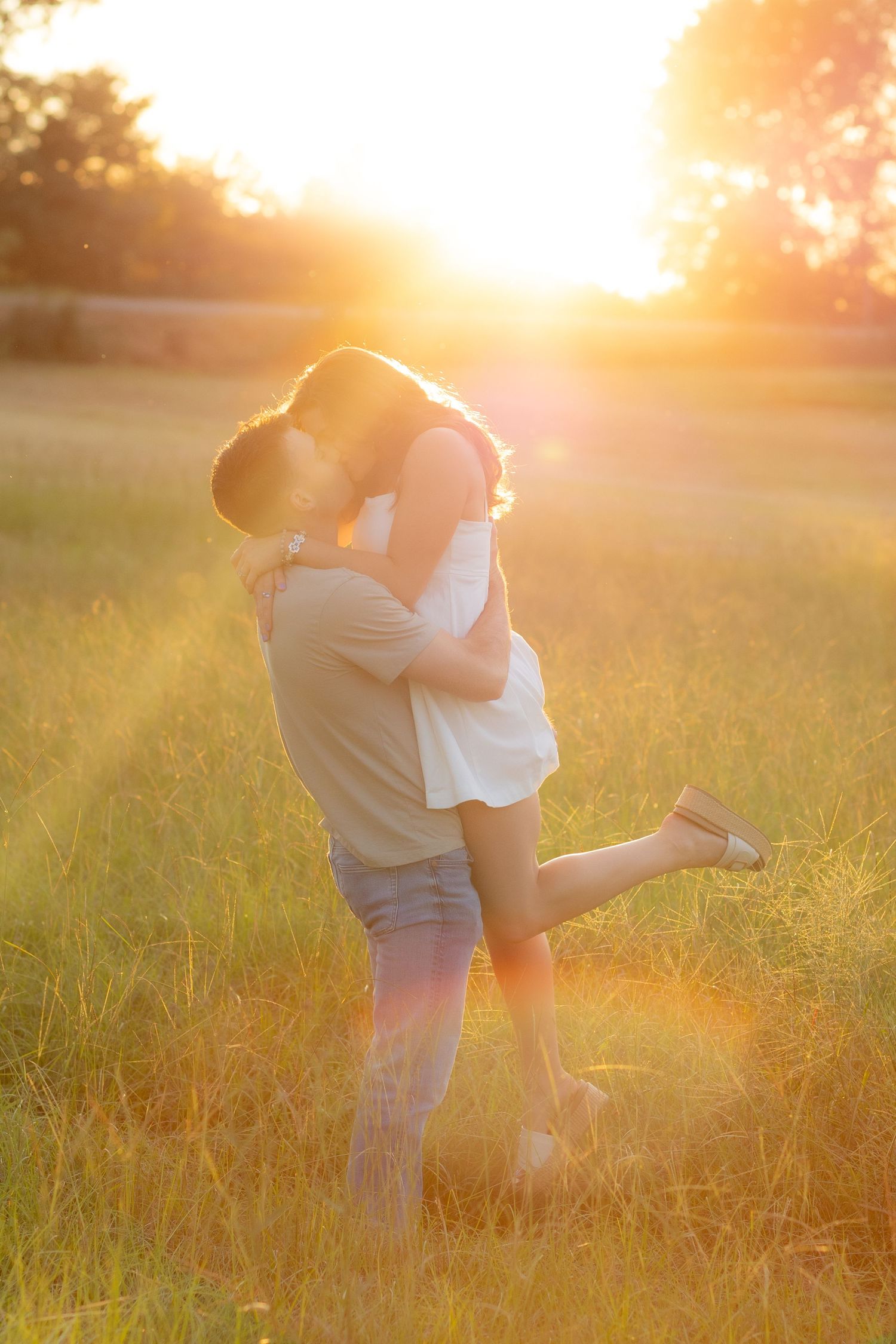 Couple holding each other in a grass field at sunset in Dothan, Alabama