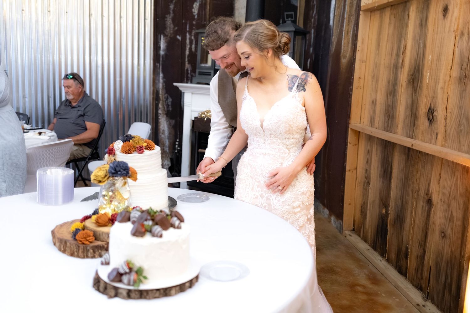 Bride and groom cut cake at their barn wedding at Hilltop Acres Wicksburg, Alabama