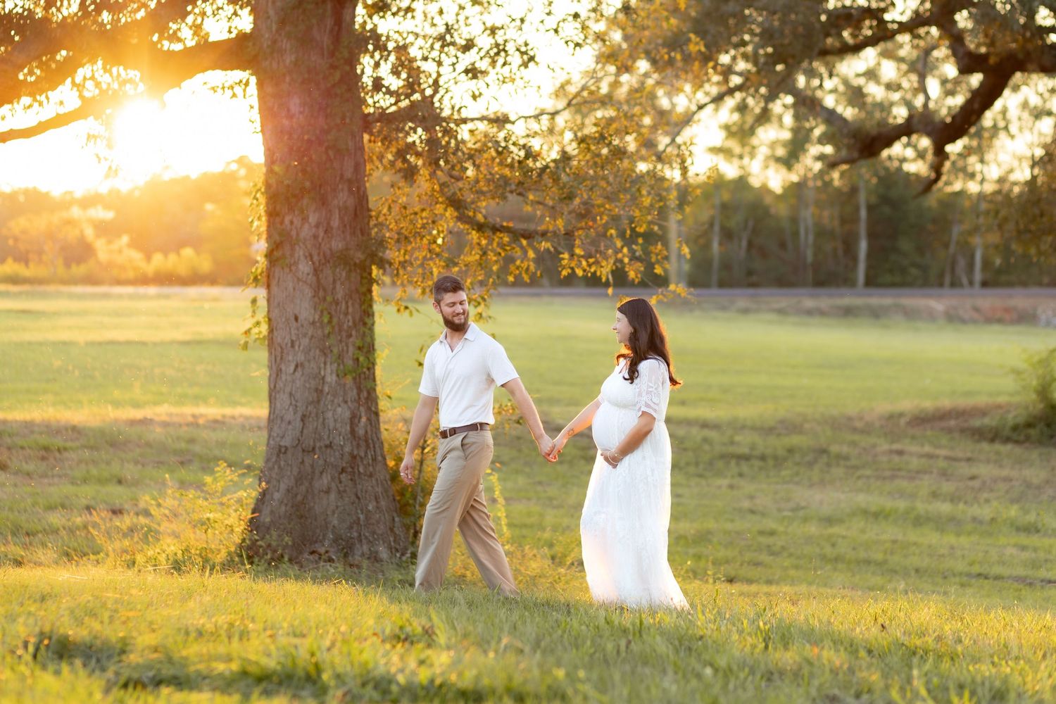 Couple maternity photos in Dothan Alabama in a grass field at sunset