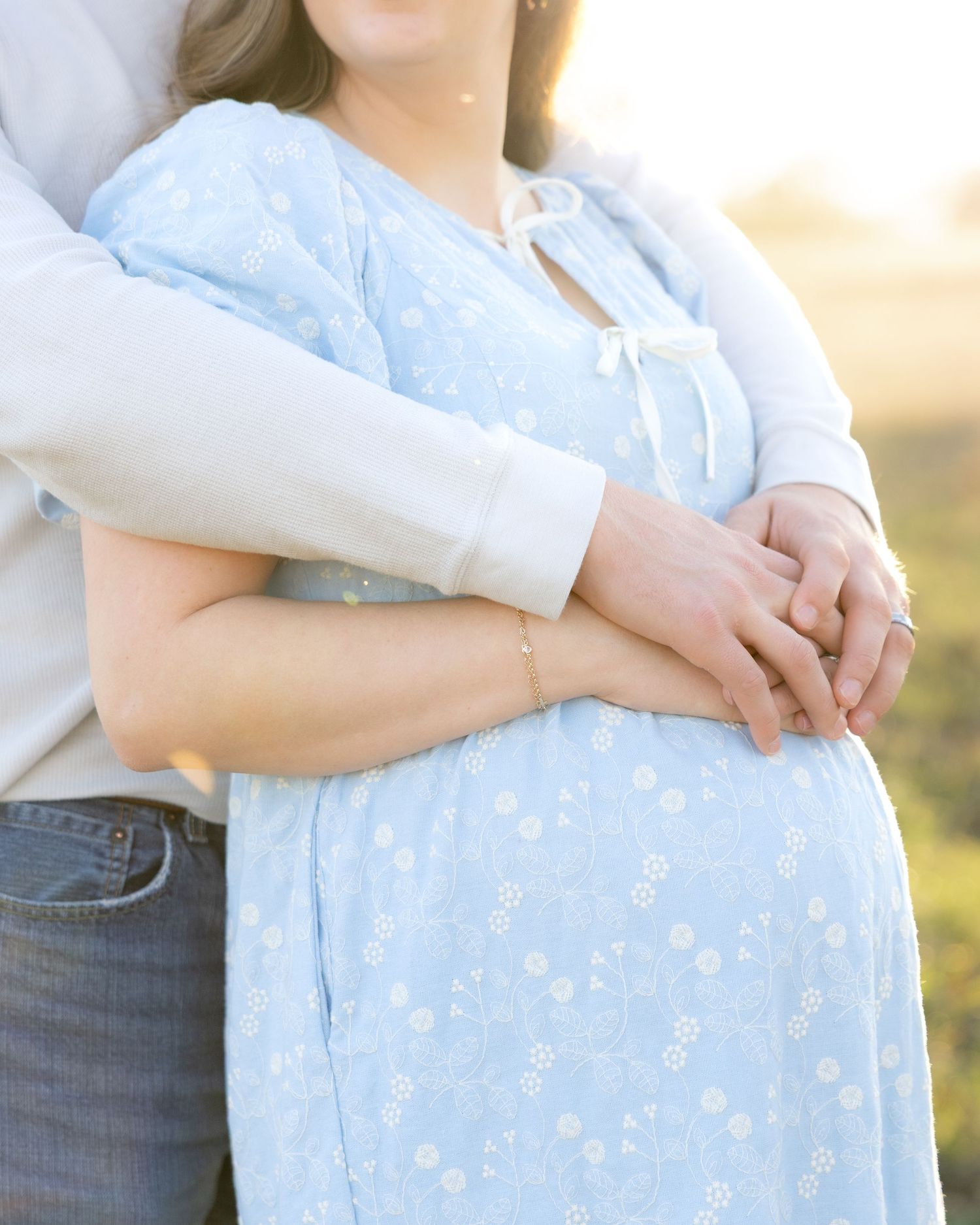 Expecting couple holding each other in a field at sunset in Dothan, Alabama