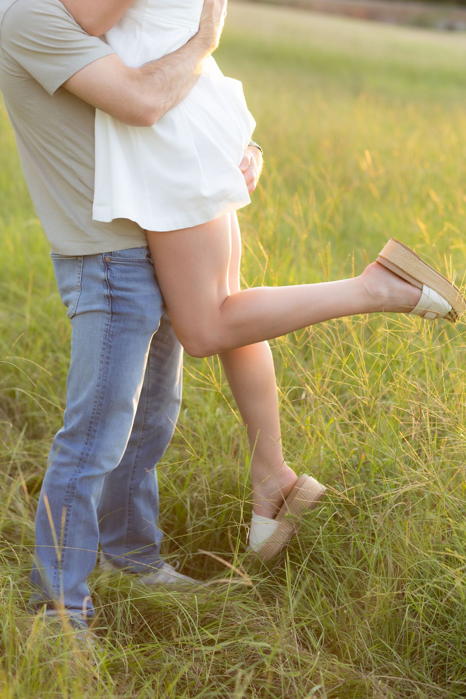 Couple holding each other in a grass field at sunset in Dothan, Alabama