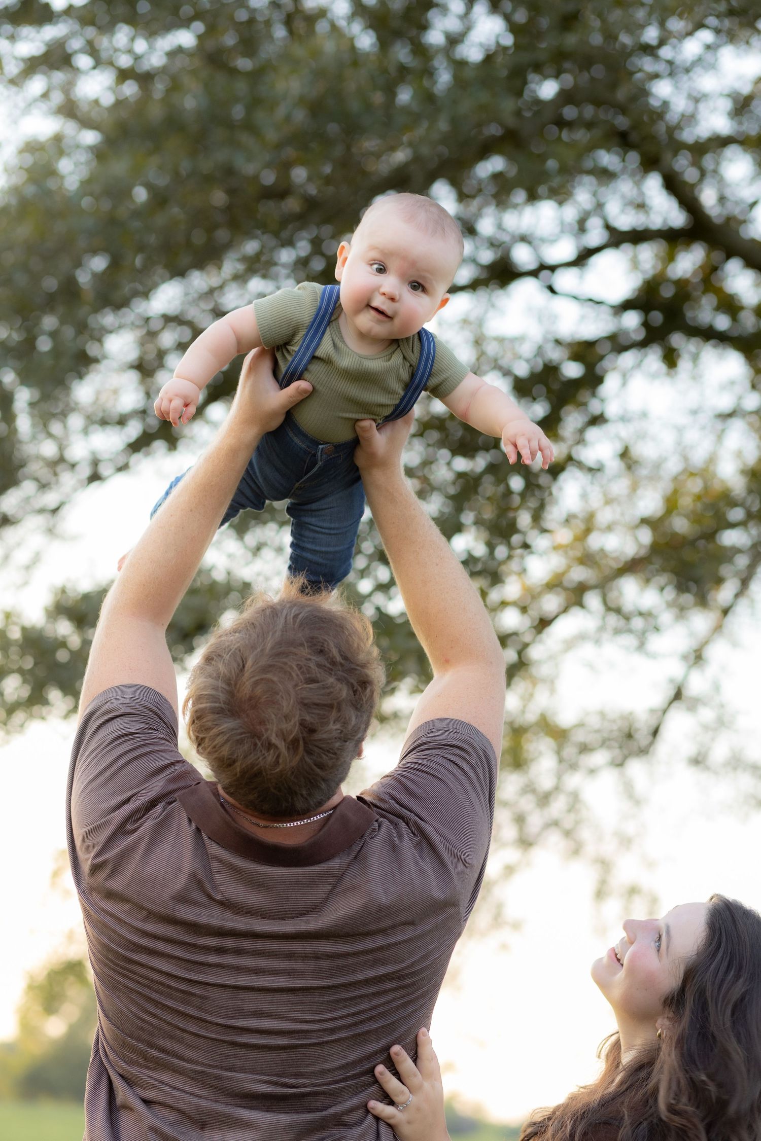 Family playing with baby in a grass field at sunset in Dothan, Alabama