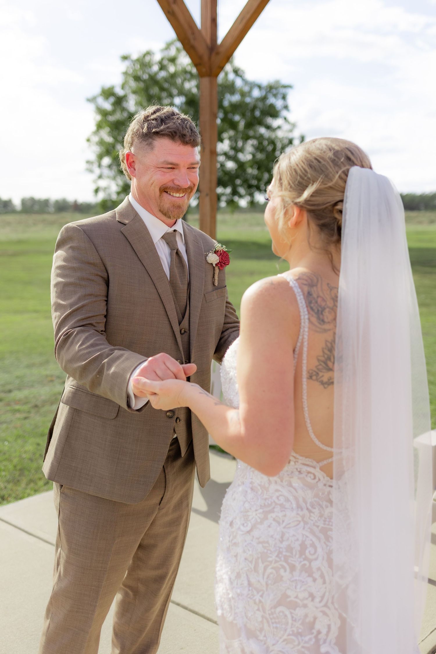 Groom first look with bride underneath the gazebo at Hilltop Acres Wicksburg, Alabama