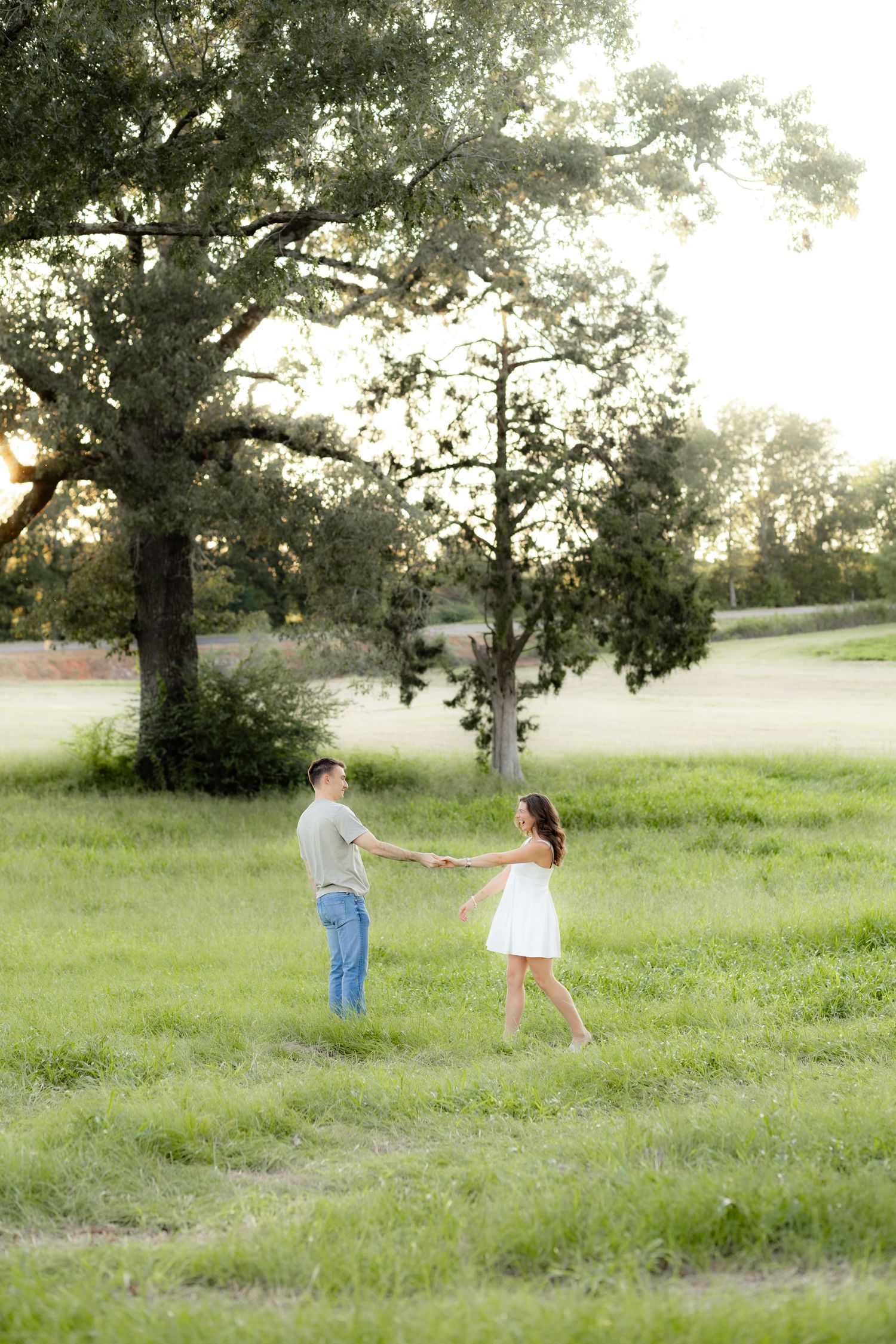 Couple holding each other in a grass field at sunset in Dothan, Alabama