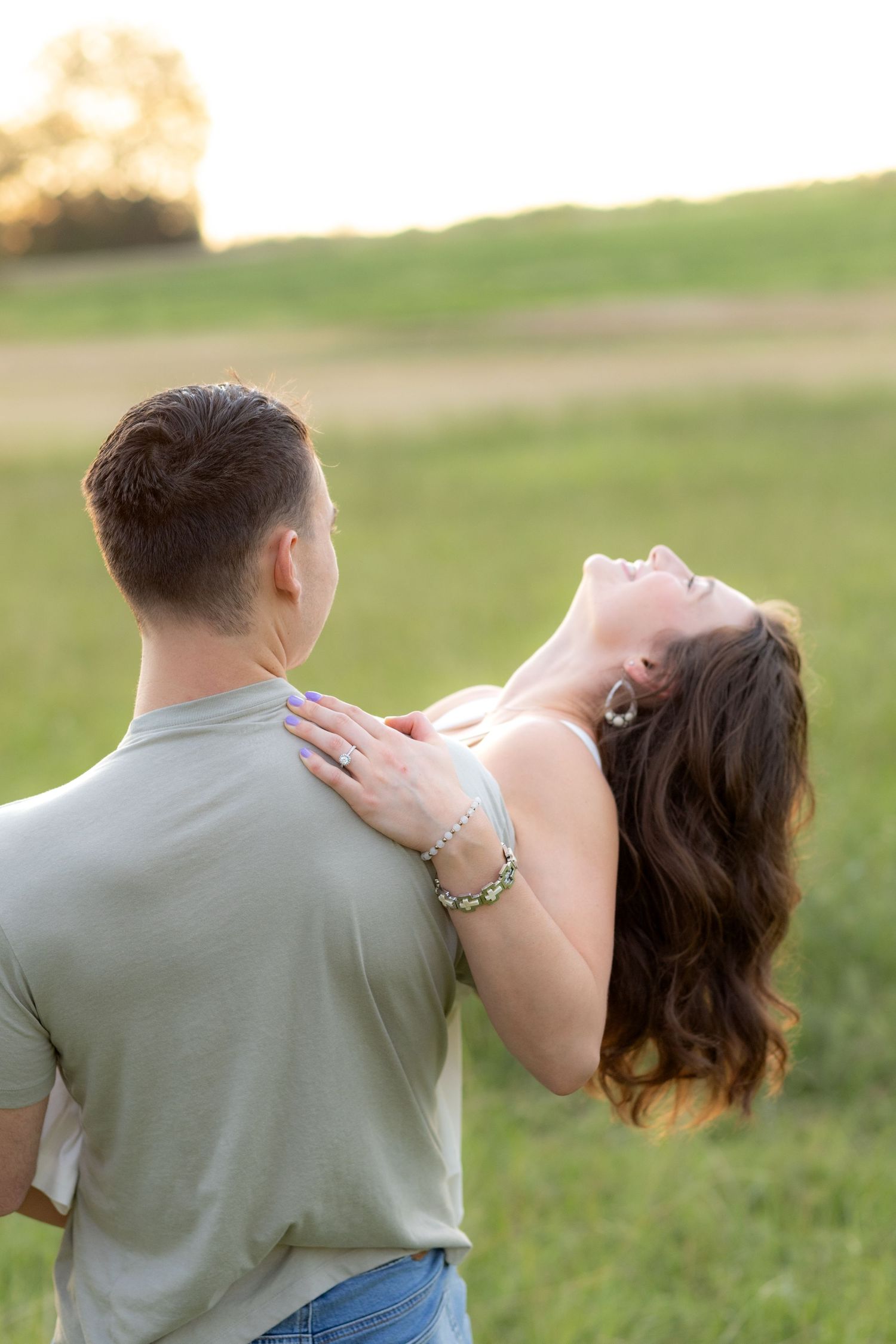 Couple playing in a grass field in Dothan, Alabama
