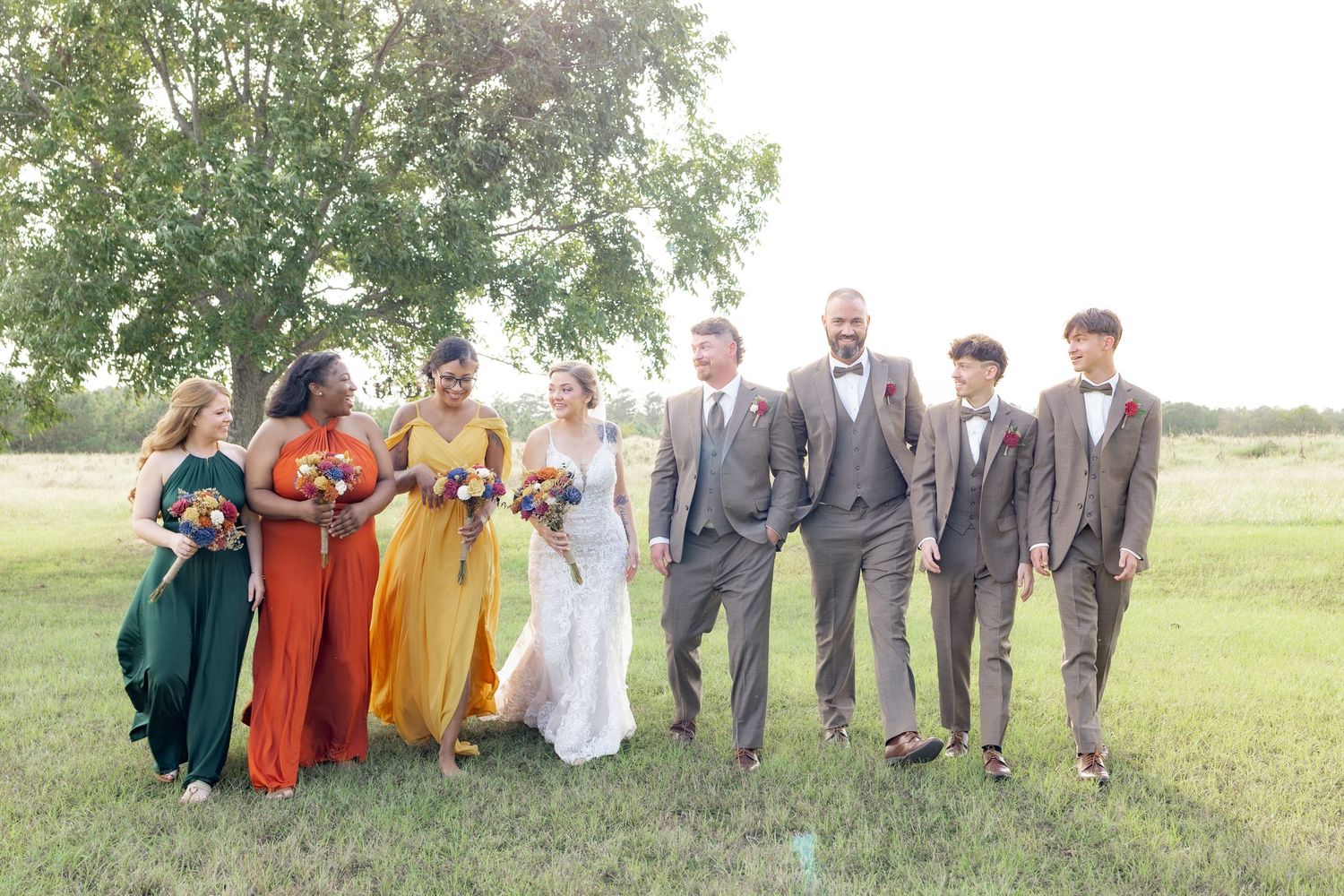 Bridal party walking in a field at sunset at Hilltop Acres Wicksburg, Alabama