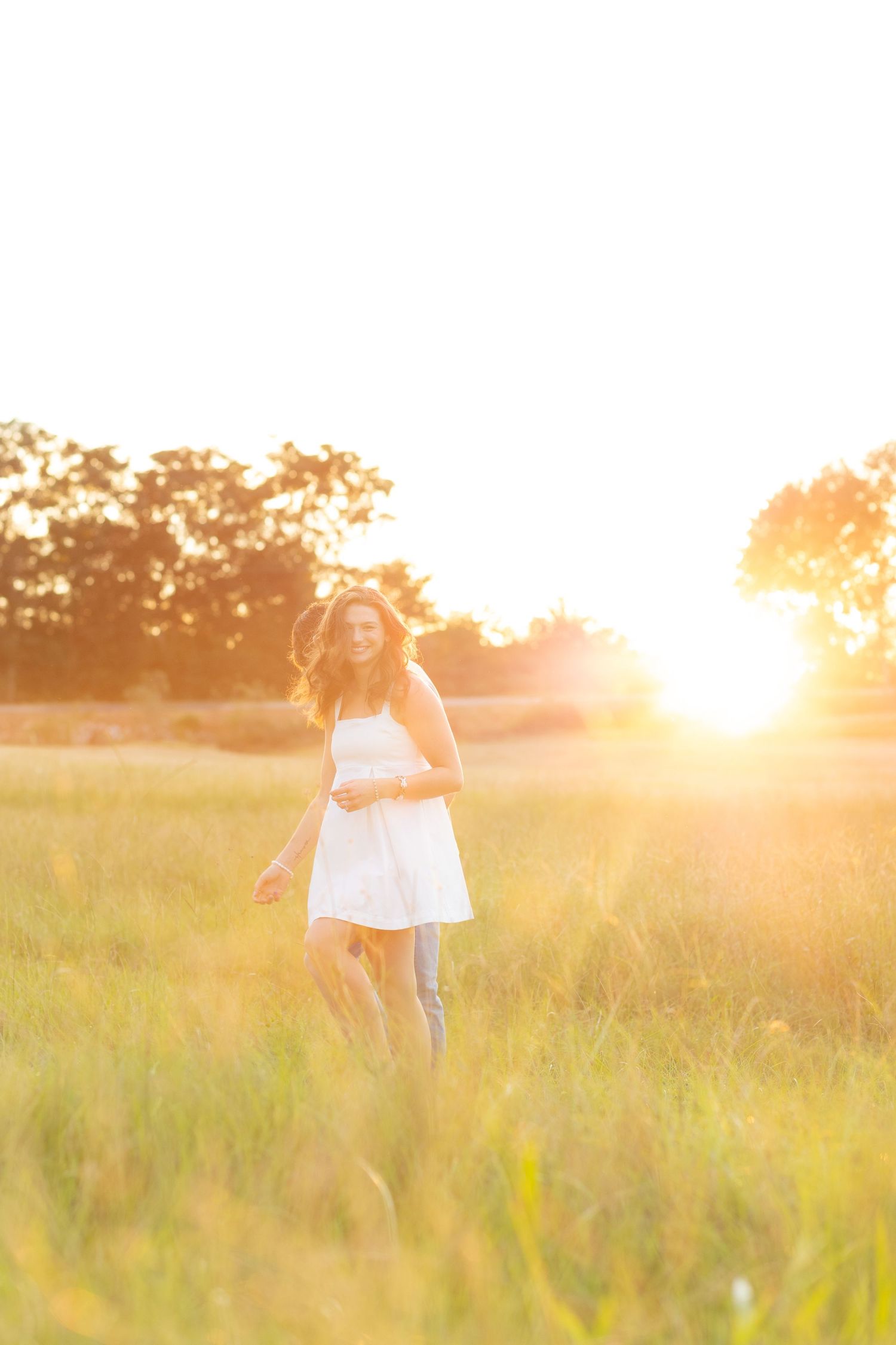 Couple running through a grass field at sunset in Dothan, Alabama