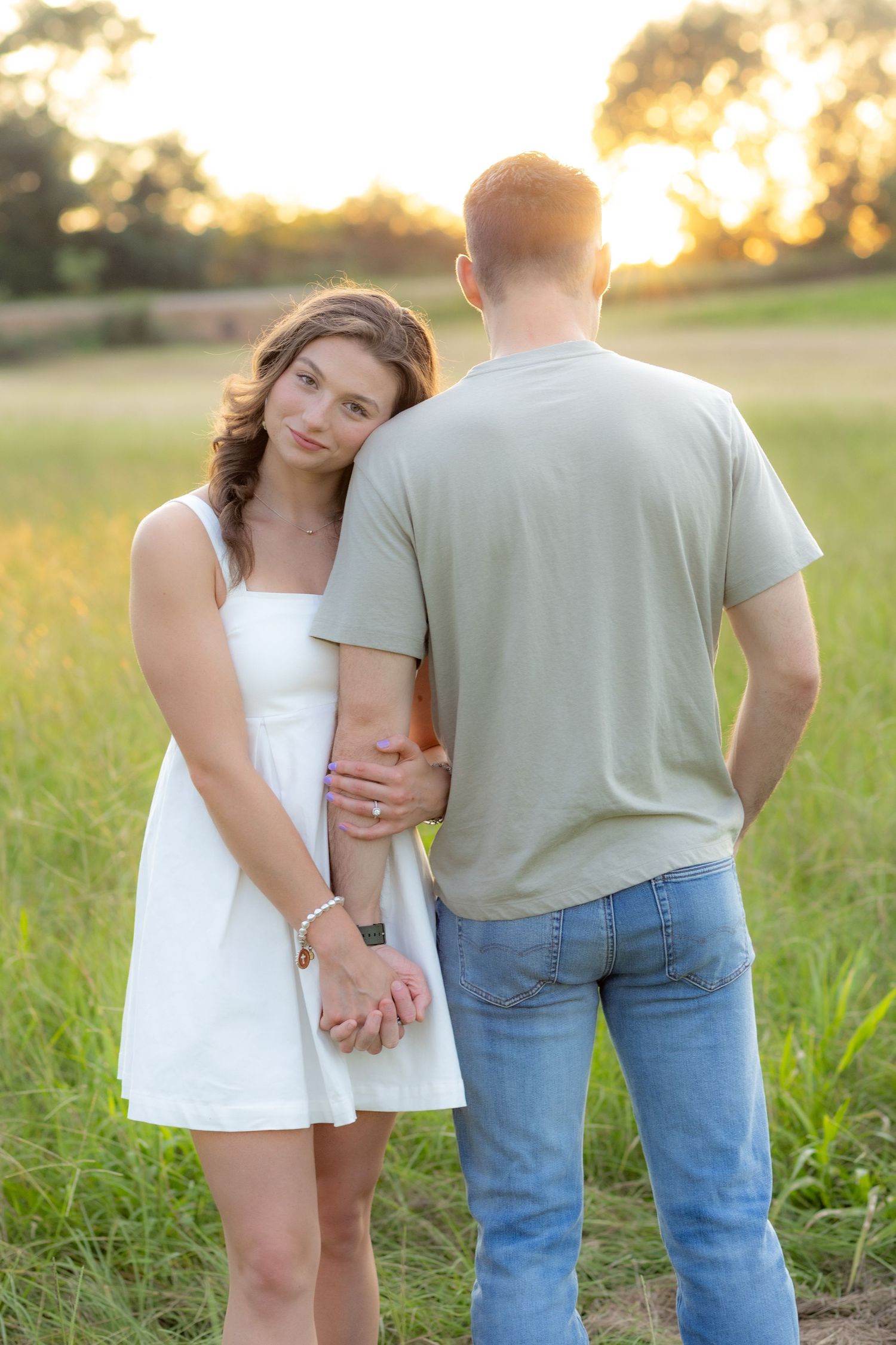 Couple holding each other in a grass field at sunset in Dothan, Alabama