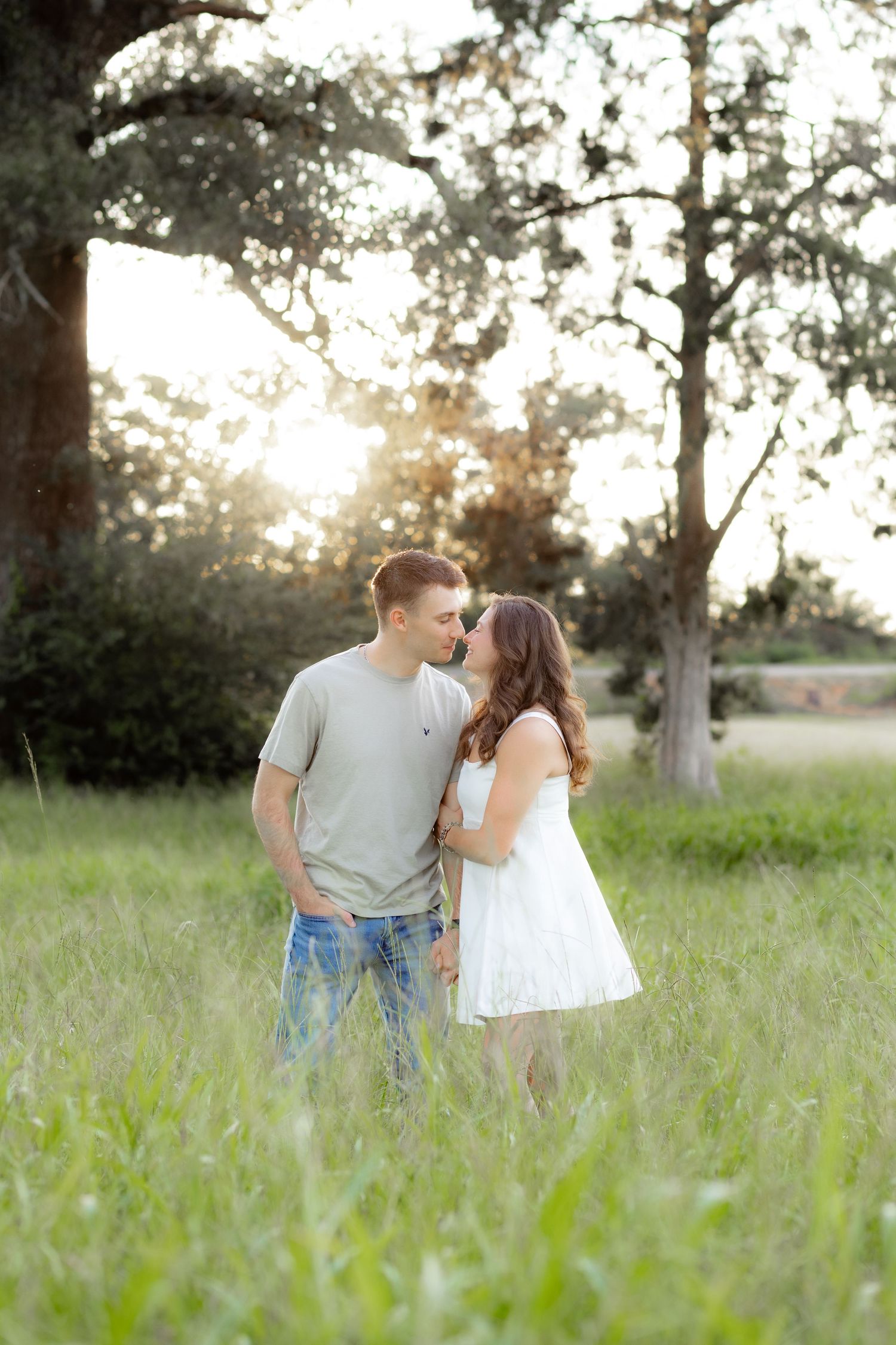 Couple walking in a grass field at sunset in Dothan, Alabama