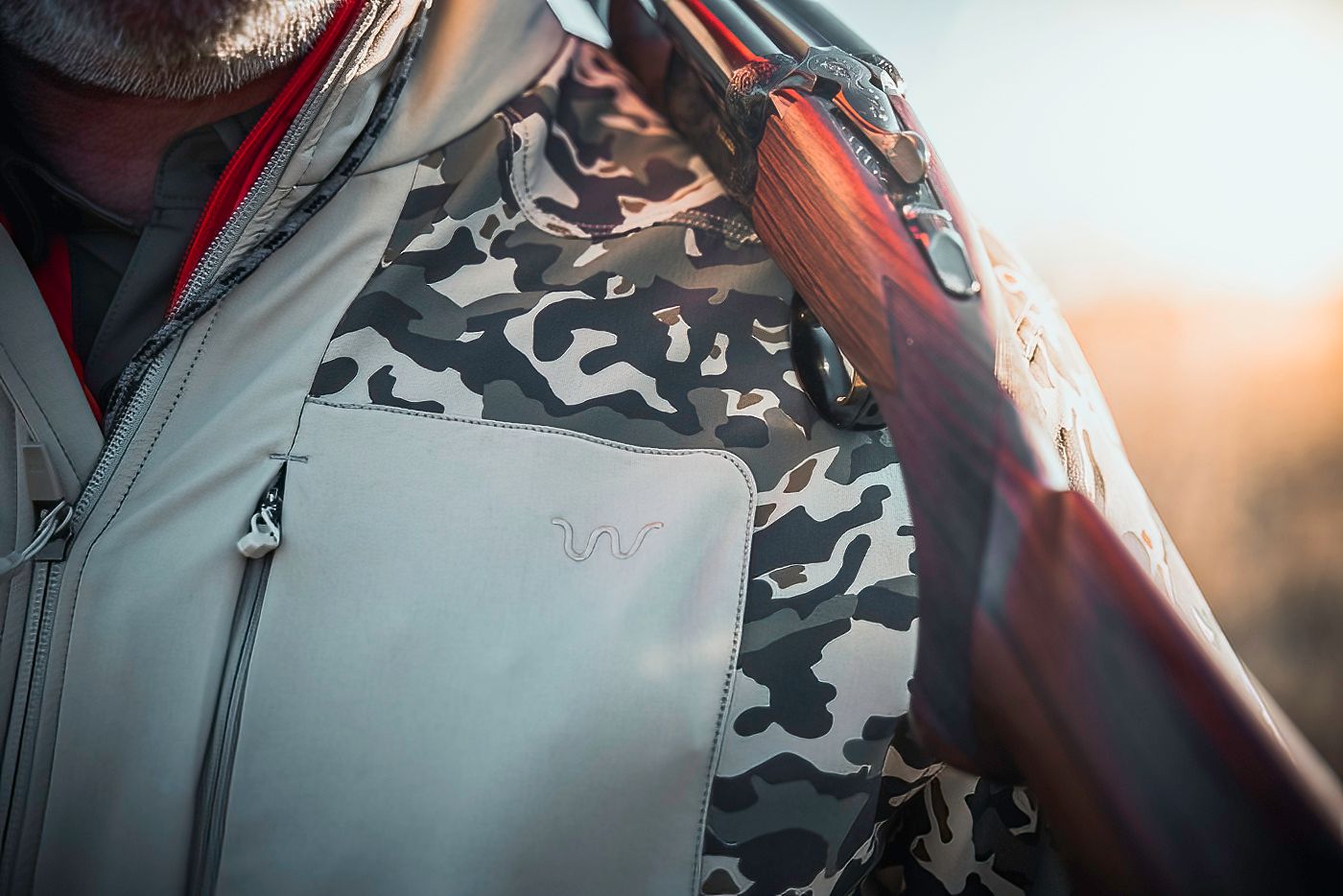 Camouflage pattern detail on hunting gear against light background.