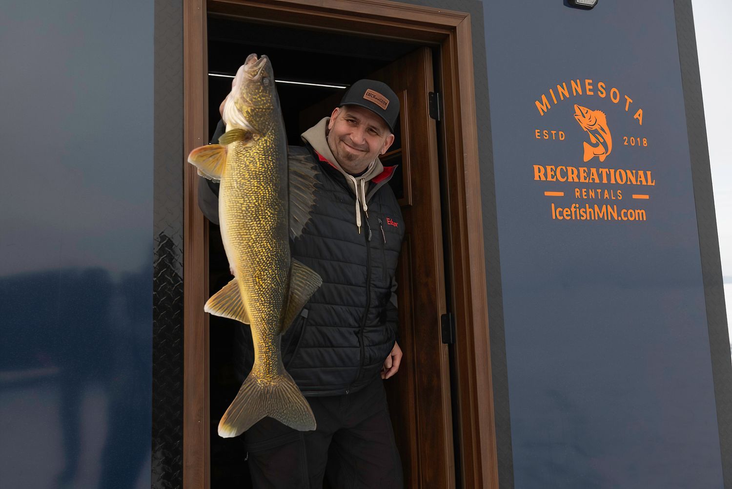 Ice fishing house with Minnesota Recreational Boating logo displayed on exterior.