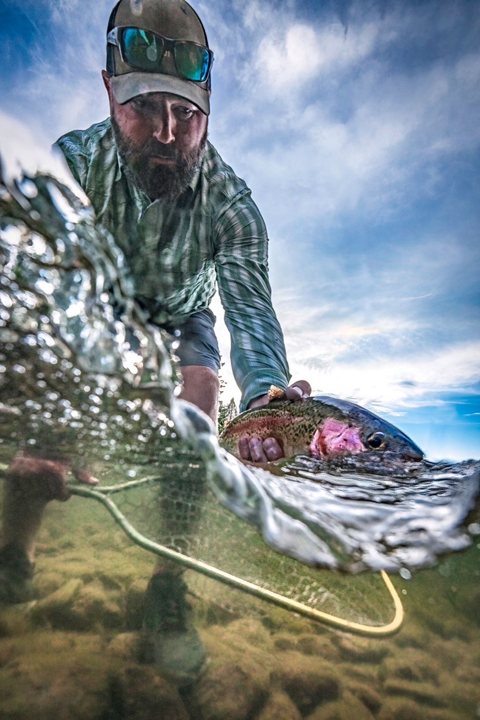 Split-shot perspective of fly fishing action with blue sky.
