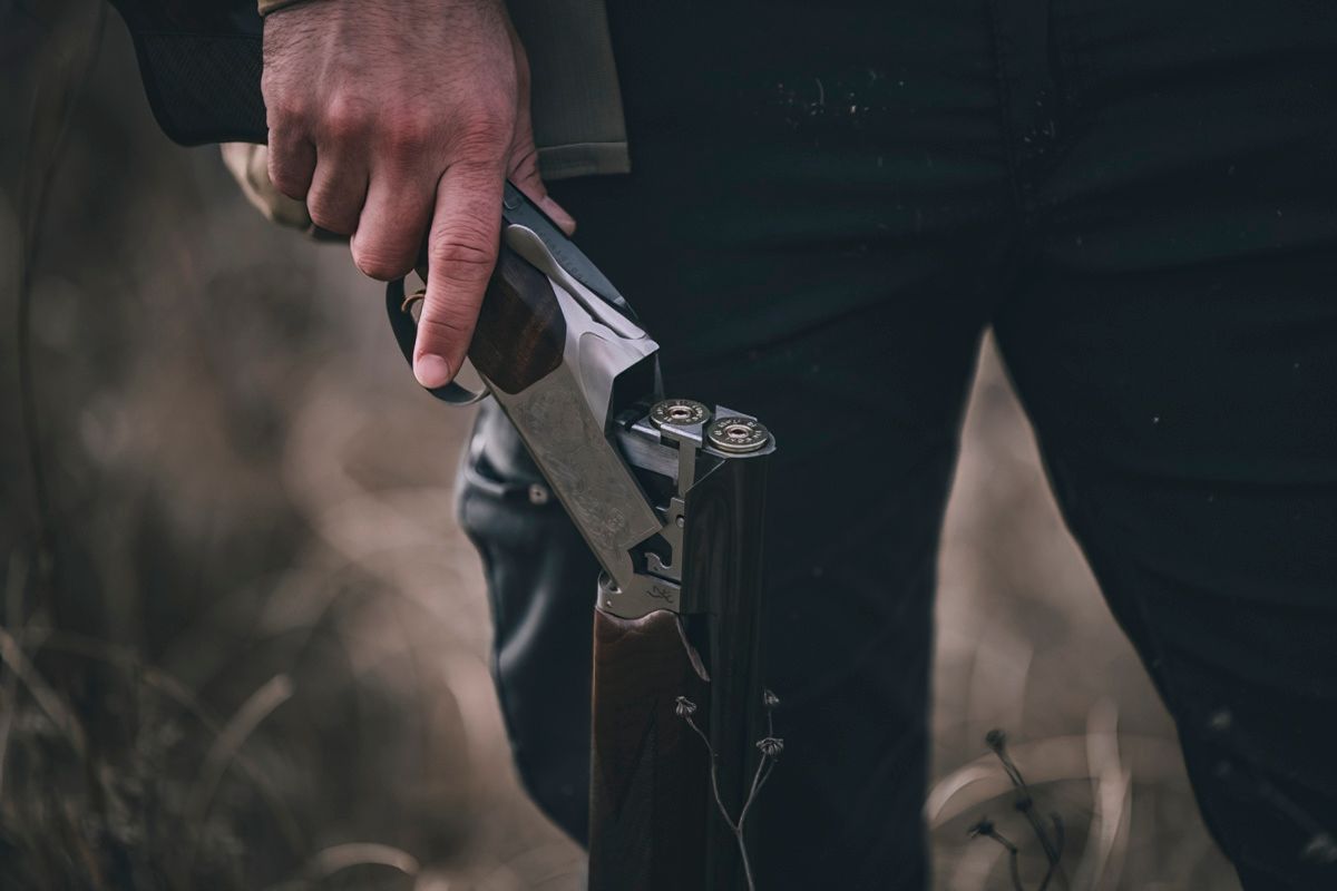 Close-up of hands loading ammunition into a gun.