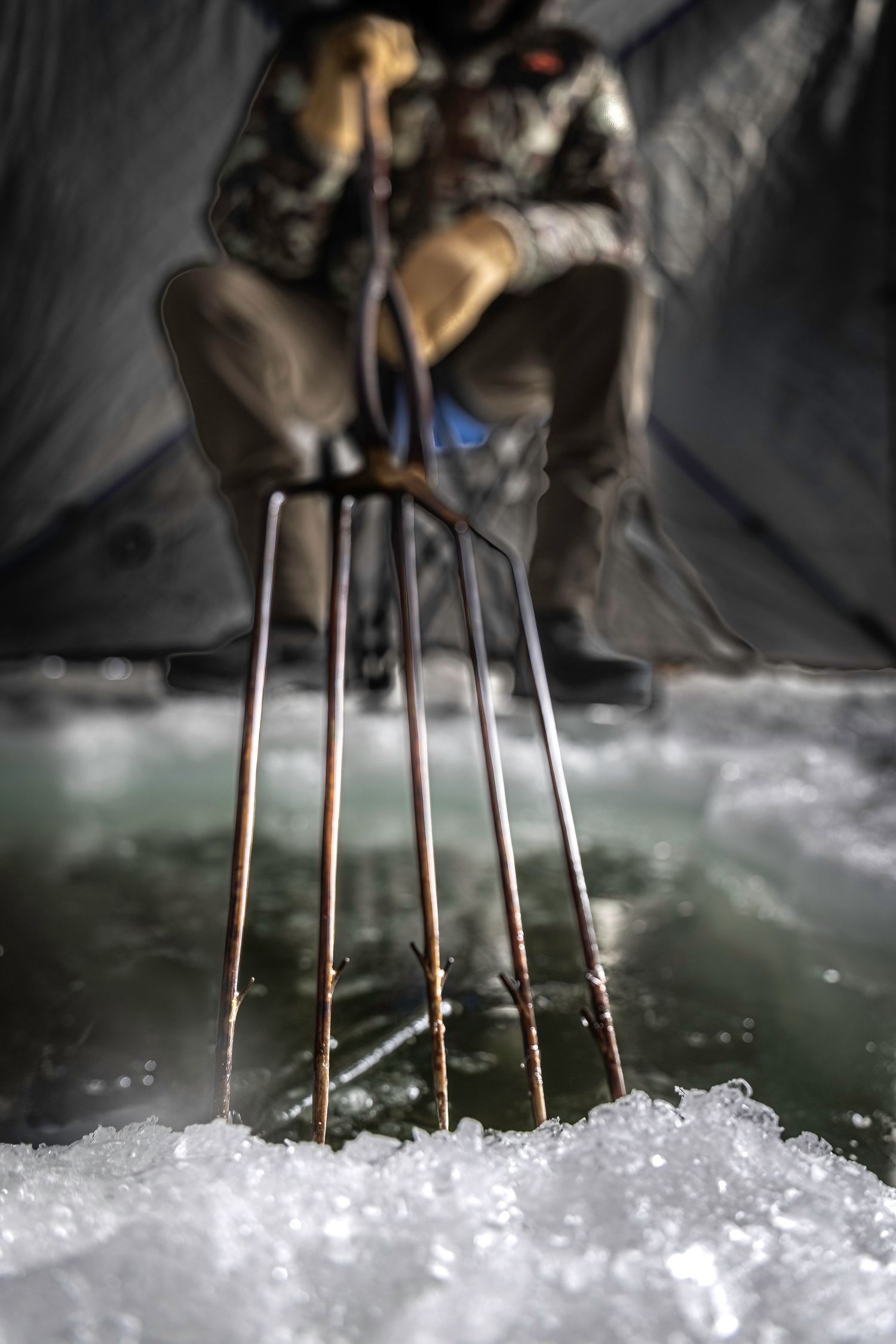 Close-up sequence showing ice fishing spearing.