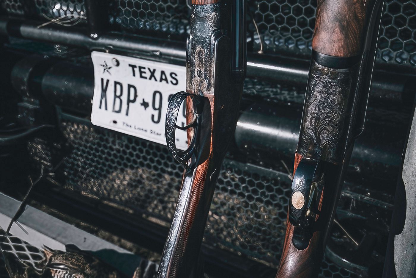 Vintage Texas license plates mounted on dark textured background with guns.