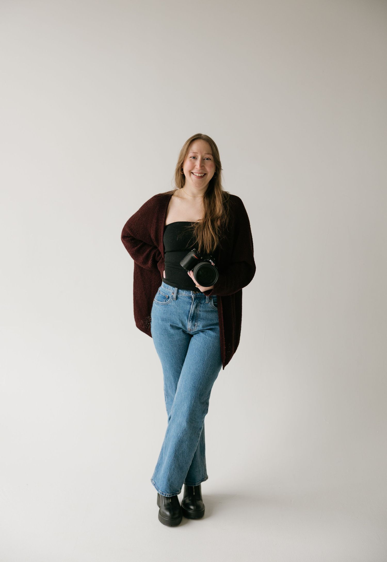 Kayla Johnson, portrait and wedding photographer based in Sioux Falls, South Dakota, smiling in studio headshot