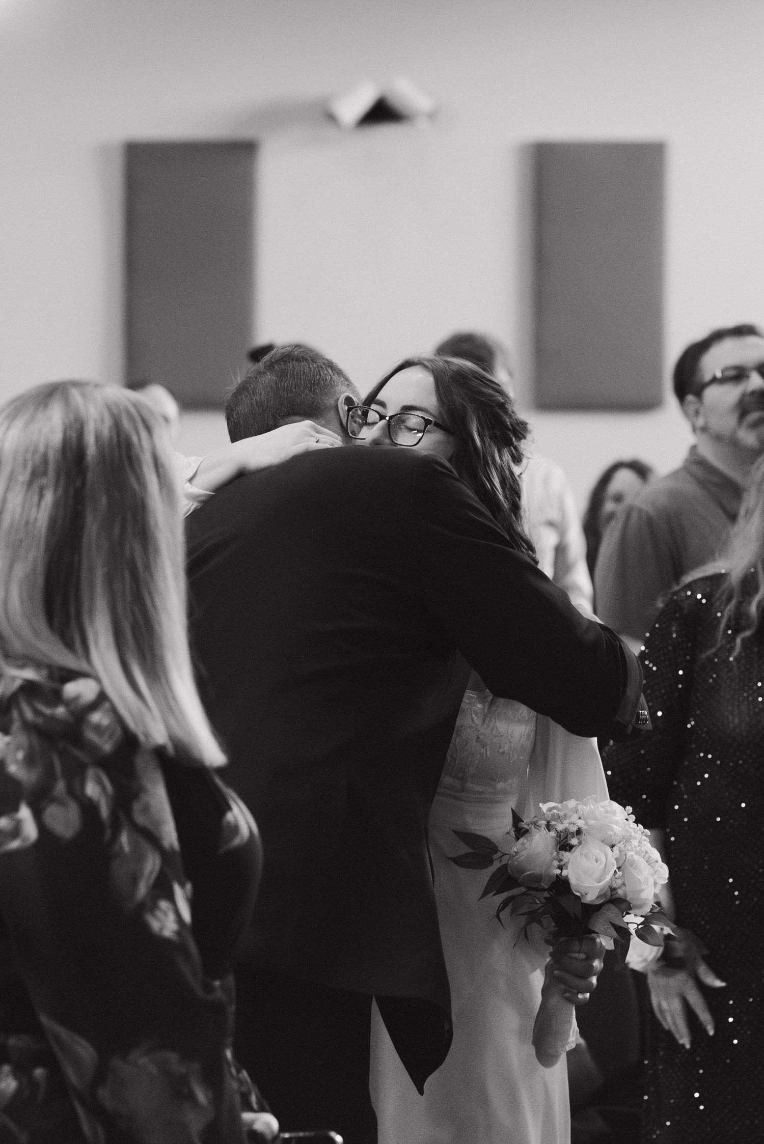 Bride and groom share an emotional hug during their wedding ceremony in a church.
