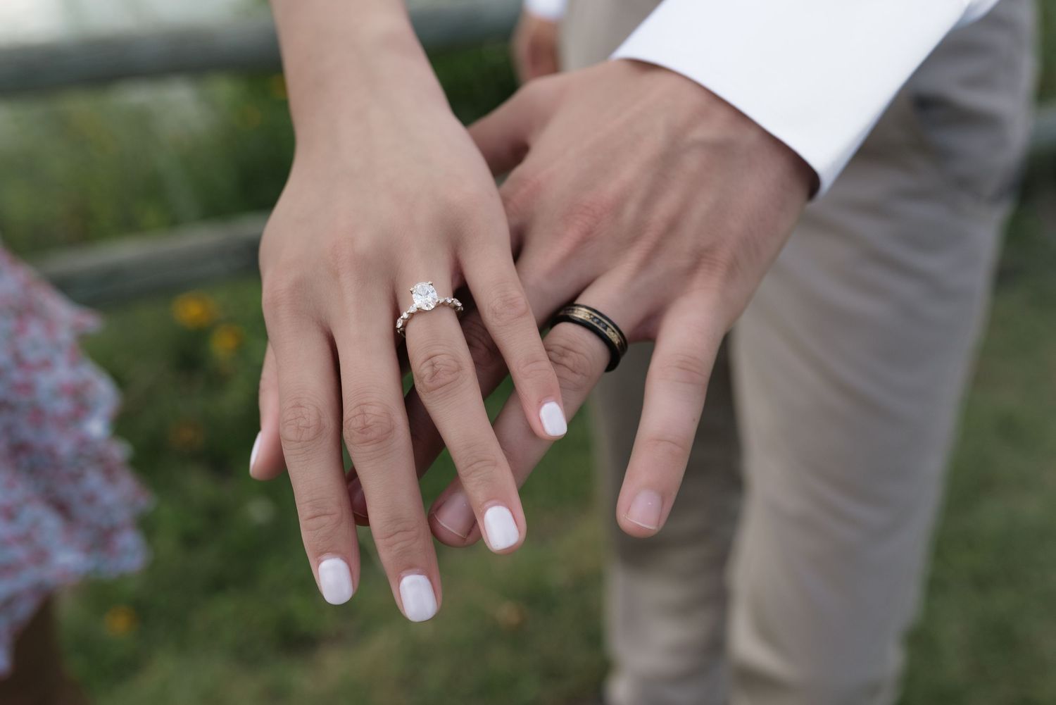 Couple displaying wedding and engagement rings on outstretched hands, symbolizing marriage and commitment.