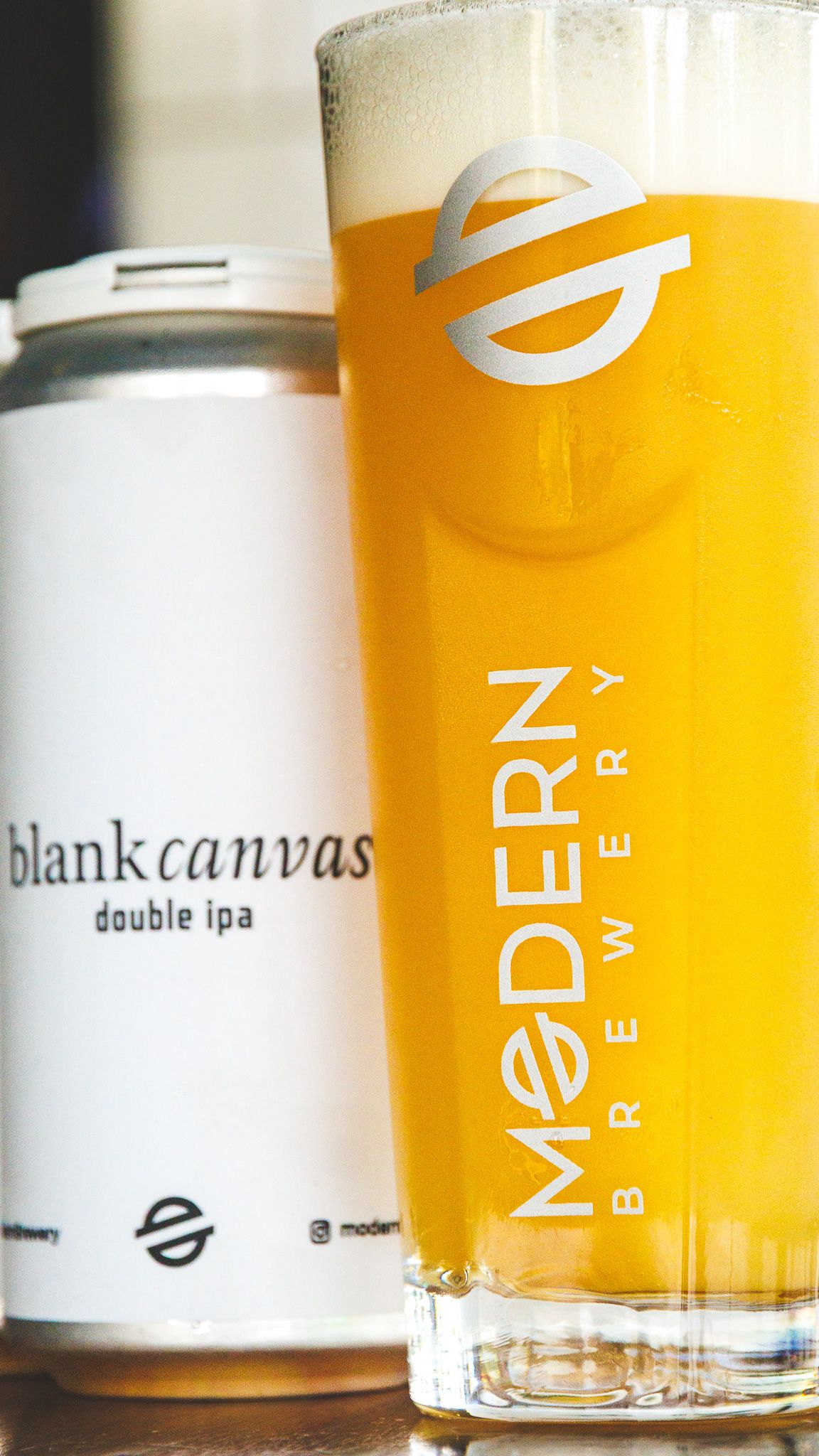 Modern Brewery Blank Canvas Double IPA beer poured into a branded glass alongside its minimalist white can.