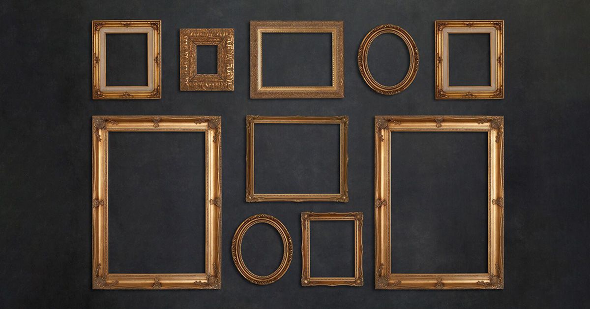 Collection of vintage empty gold picture frames arranged on dark wall.