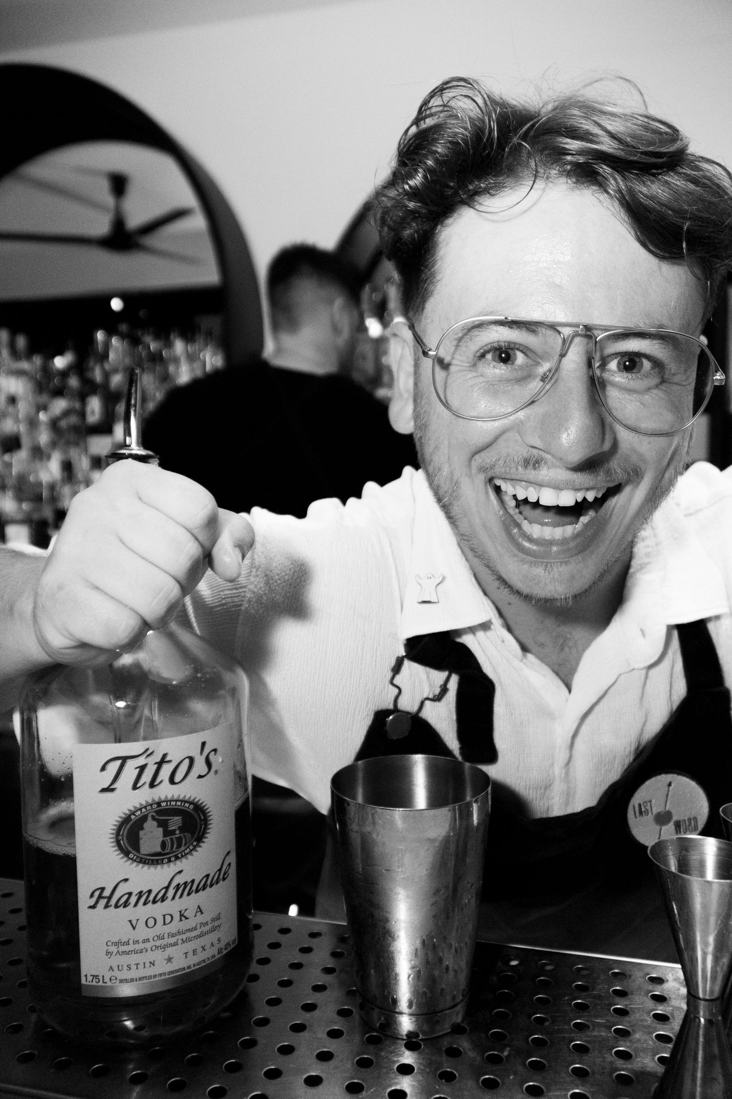 Black and white photo sequence showing bartender mixing drinks with Tito's vodka bottle visible.