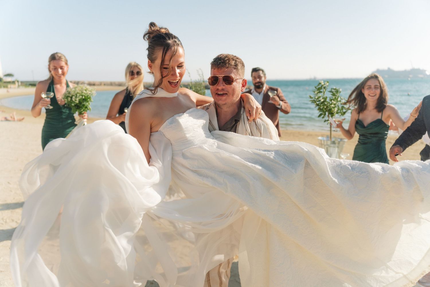 Beachside wedding celebration with flowing white dress catching the ocean breeze.