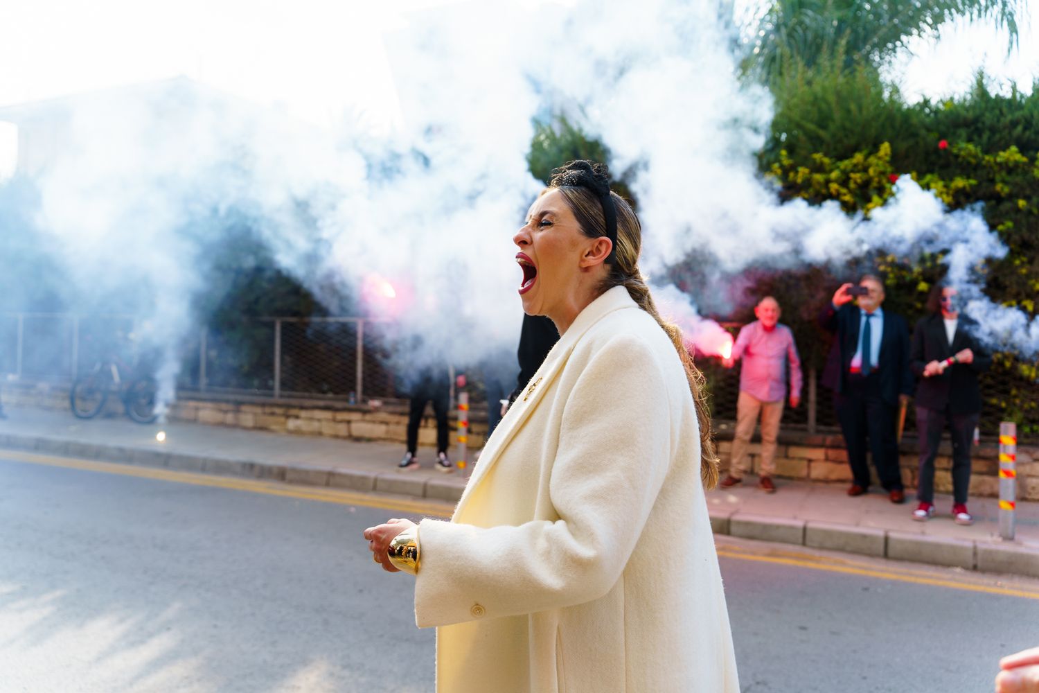 Smoke fills the air at an outdoor celebration event with guests in formal attire.
