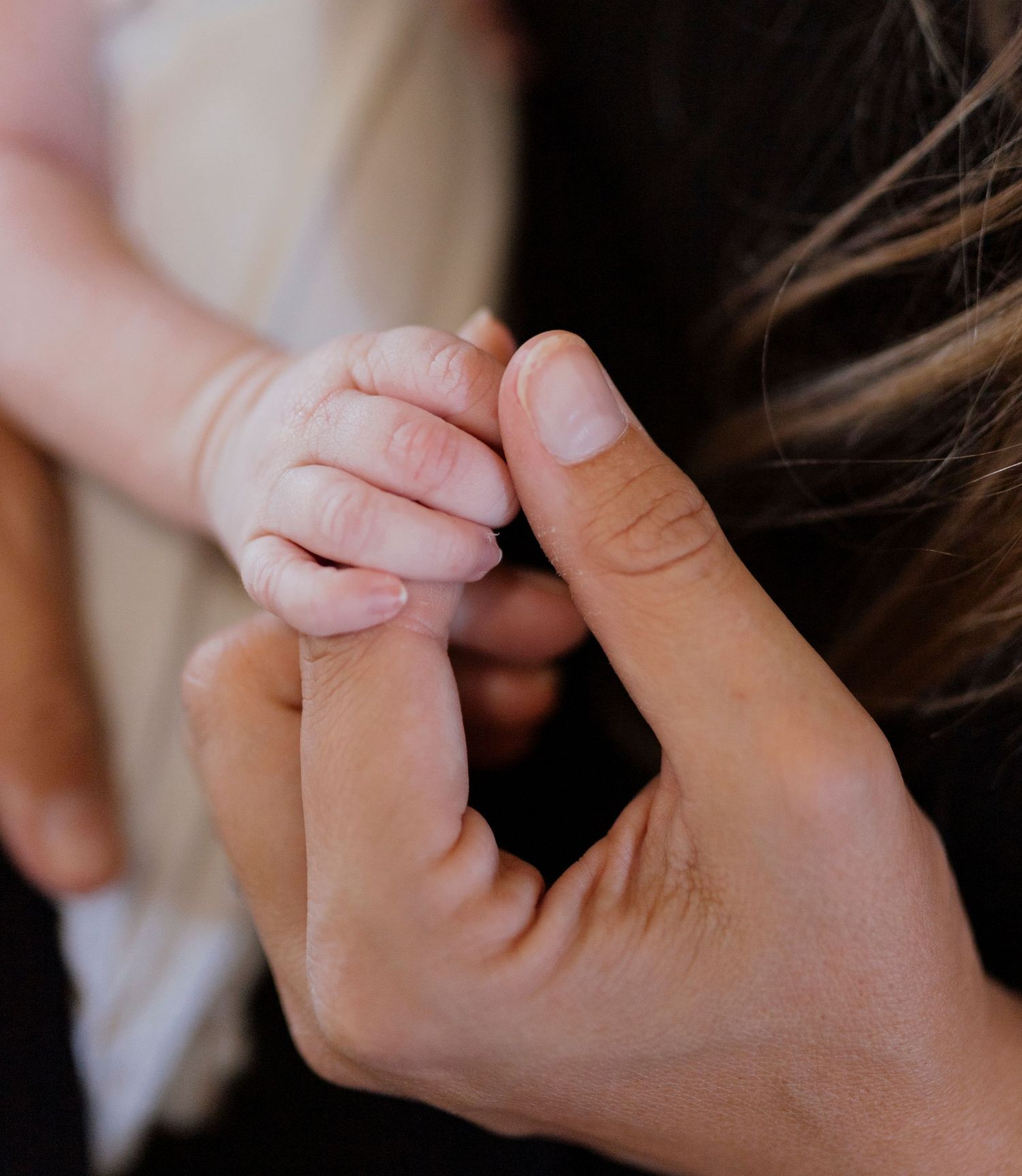 Infant holding moms hand in maternity and mom and baby photography in Hawaii