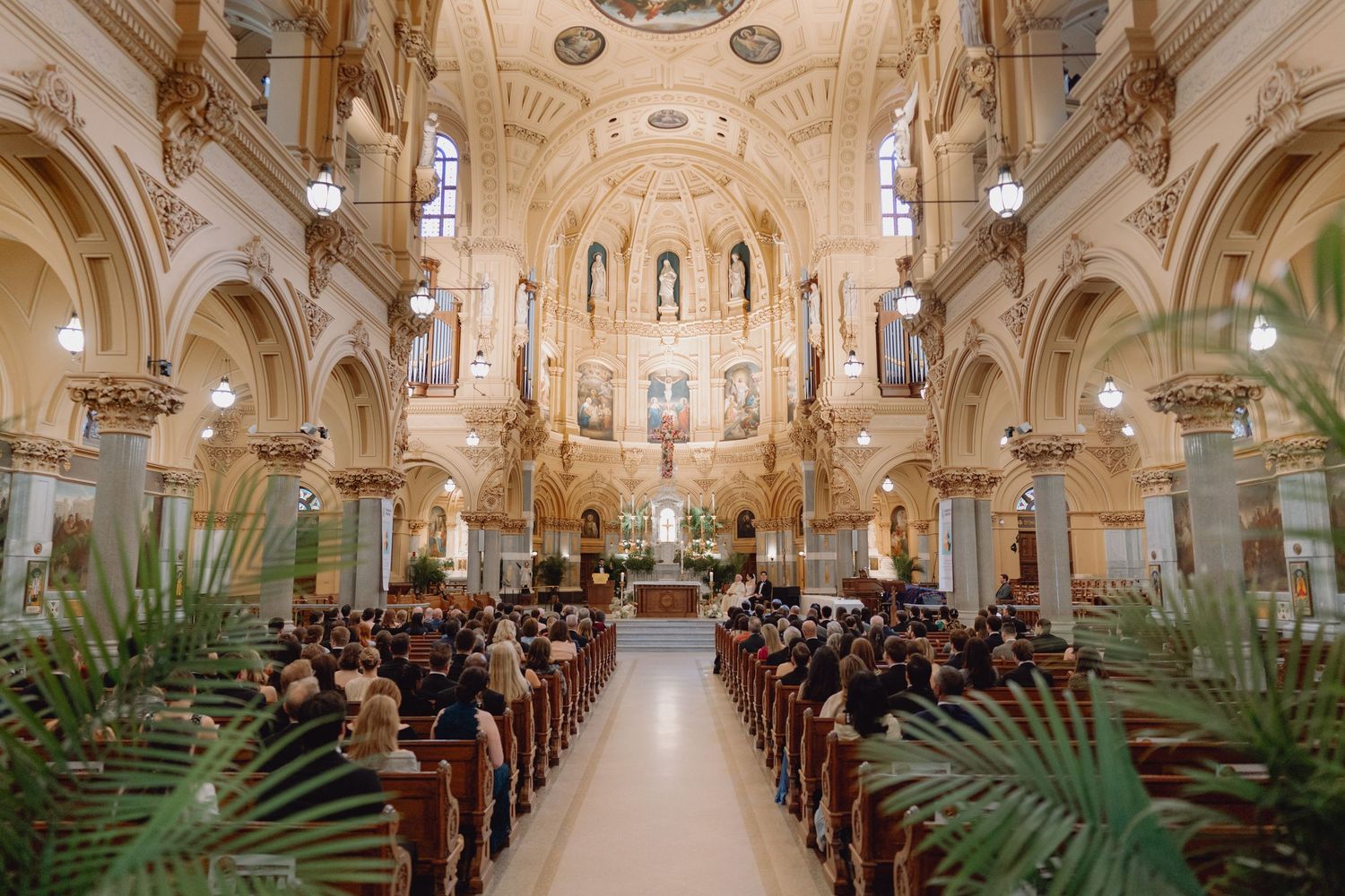 Stunning ornate Catholic church filled with wedding guests during elegant ceremony.