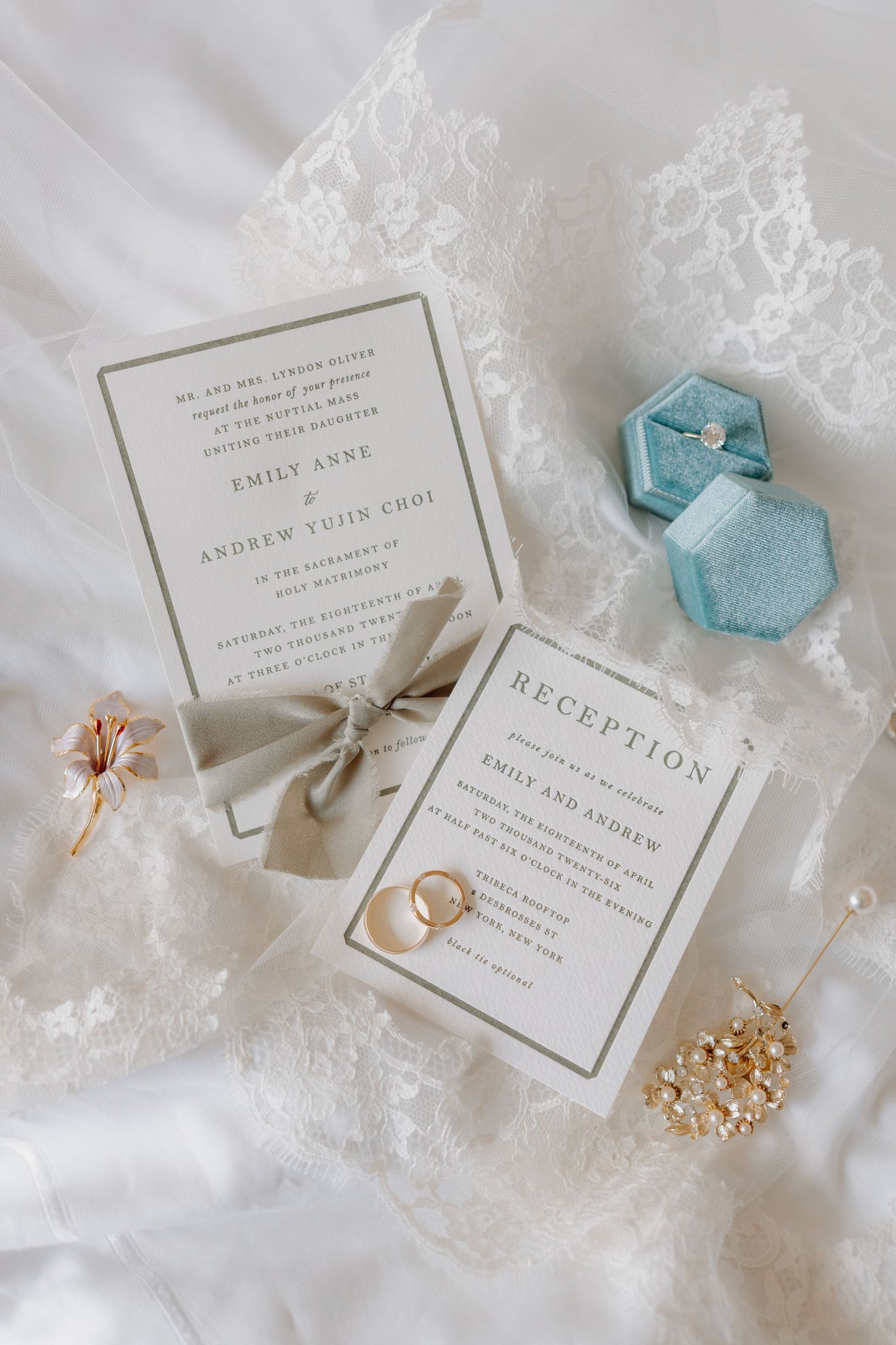 Wedding invitation suite with reception card, gold rings, floral details, and a blue velvet ring box.