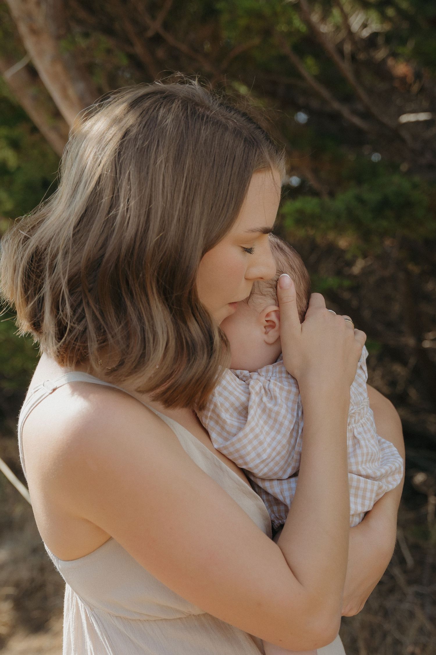 A mother holding her daughter close at a beach in Carmel, CA