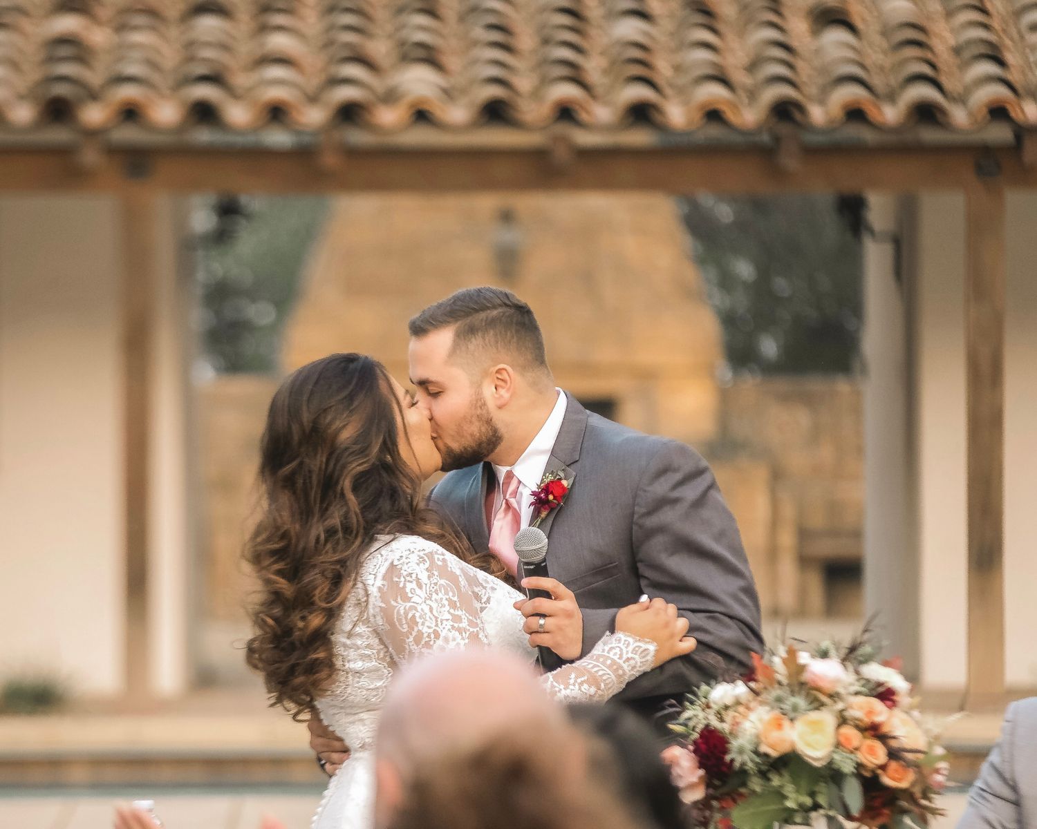 A couple kissing on the their wedding day.