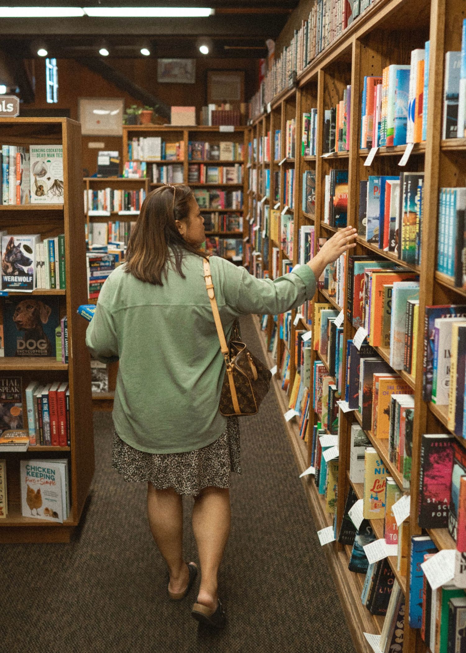 A woman browsing through a bookstore in Santa Barbara, CA.