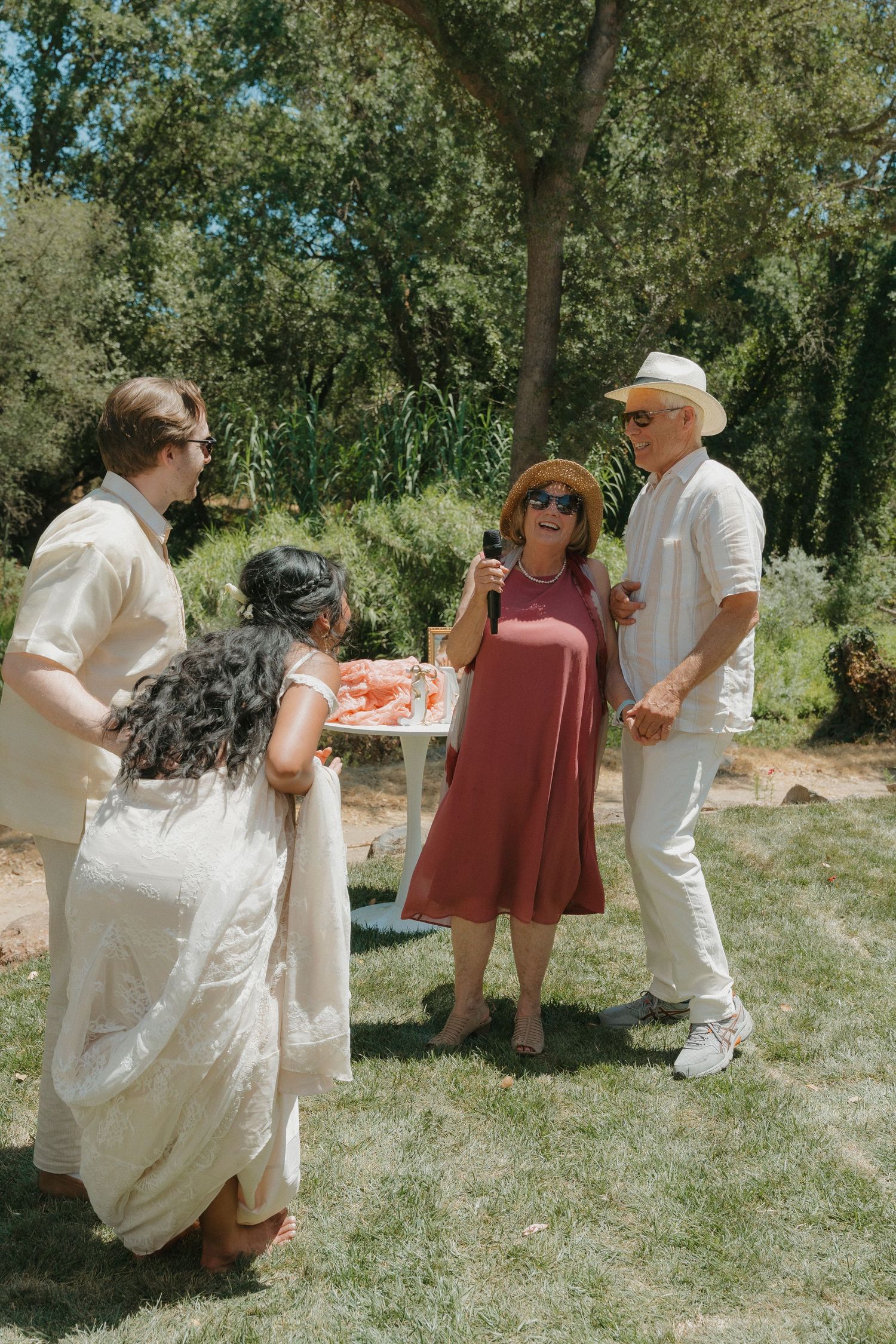 Wedding guests socializing outdoors in summer, with a woman in red dress holding a drink in Granite Bay, CA.